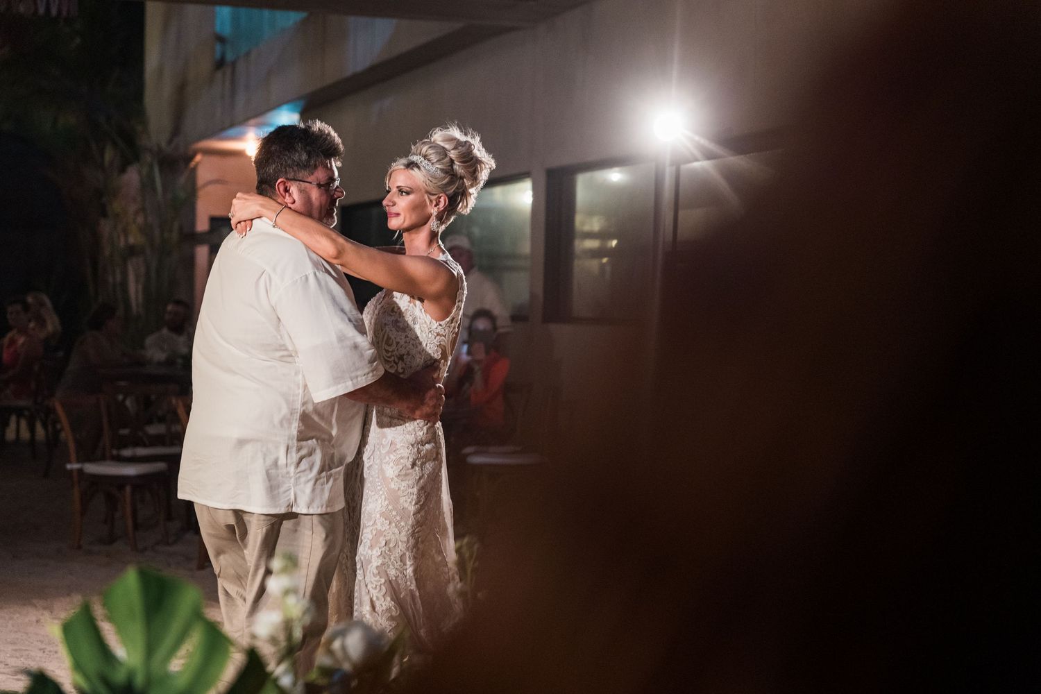 Bride and groom share a romantic first dance outdoors at their evening wedding reception.