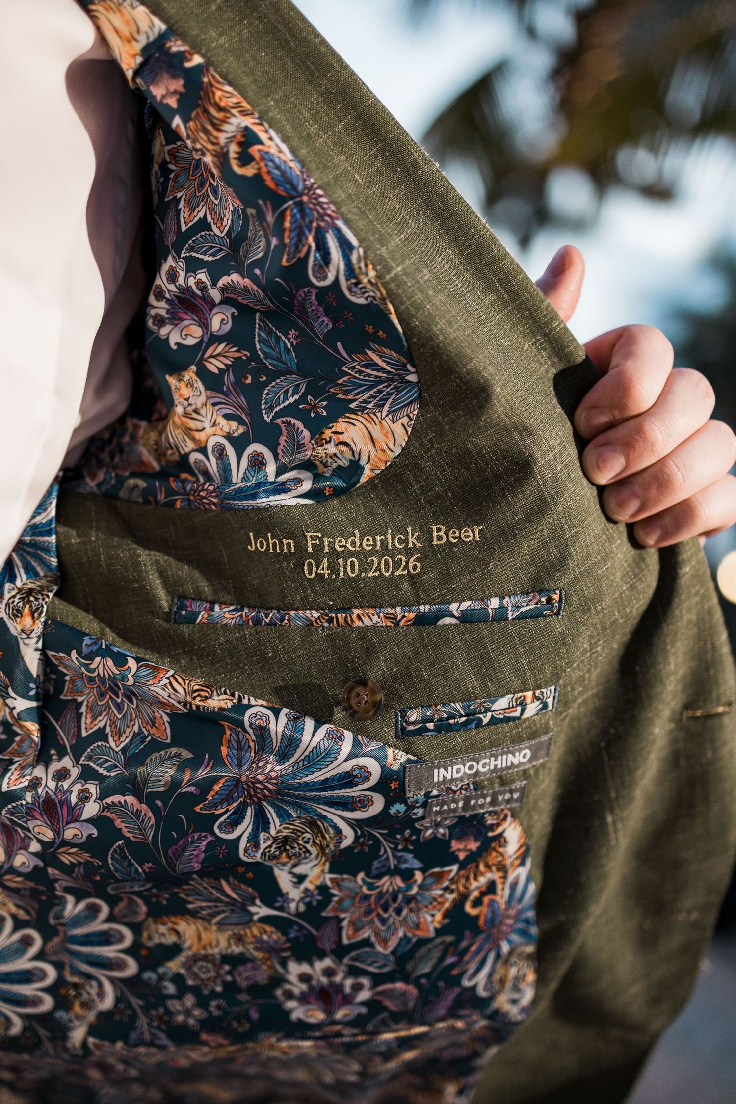 Indochino olive green suit jacket with floral lining and personalized embroidery reading John Frederick Bear 04.10.2026.