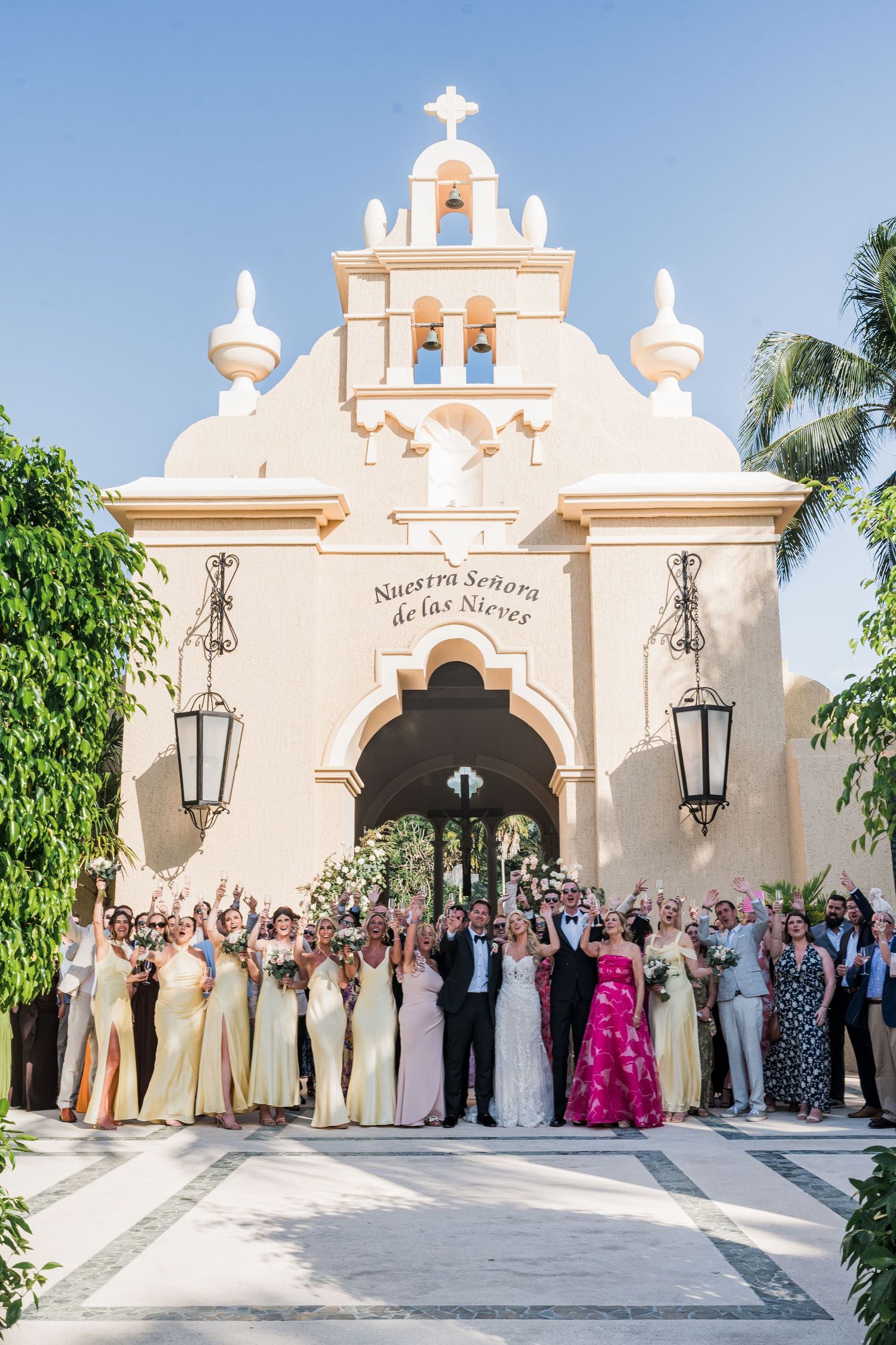 Wedding party celebrates outside Nuestra Señora de las Nieves chapel in a sunny destination wedding.