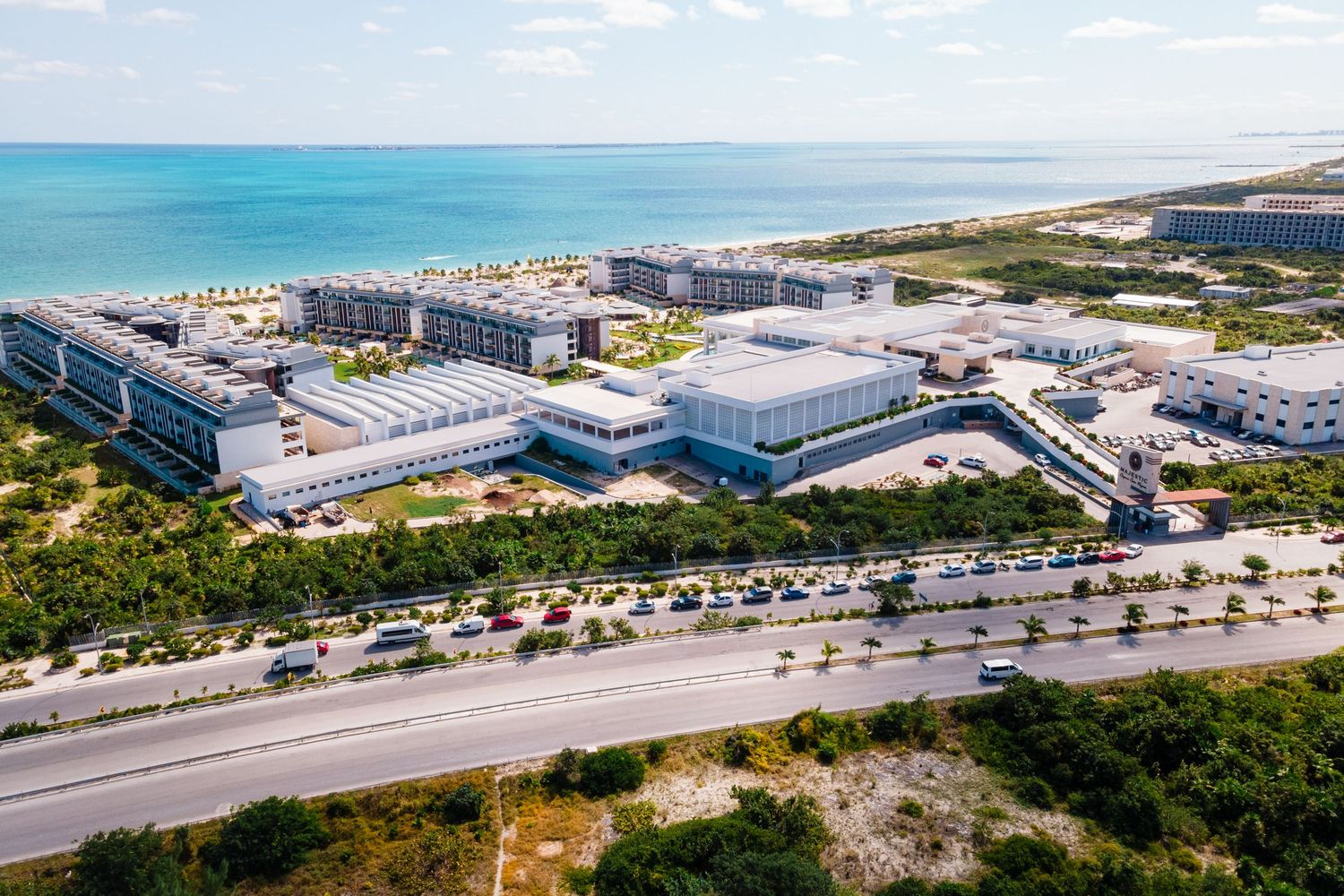 Aerial view of a large beachfront resort complex with turquoise Caribbean waters and white sandy shores.