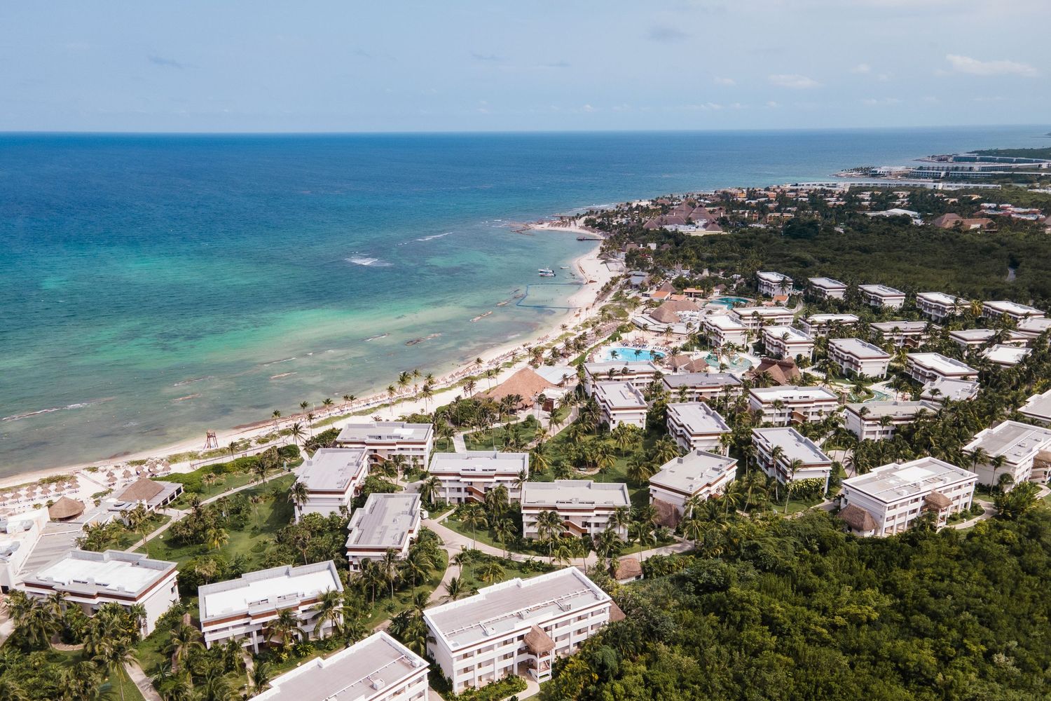Aerial view of beachfront resort with turquoise Caribbean waters and lush tropical greenery.