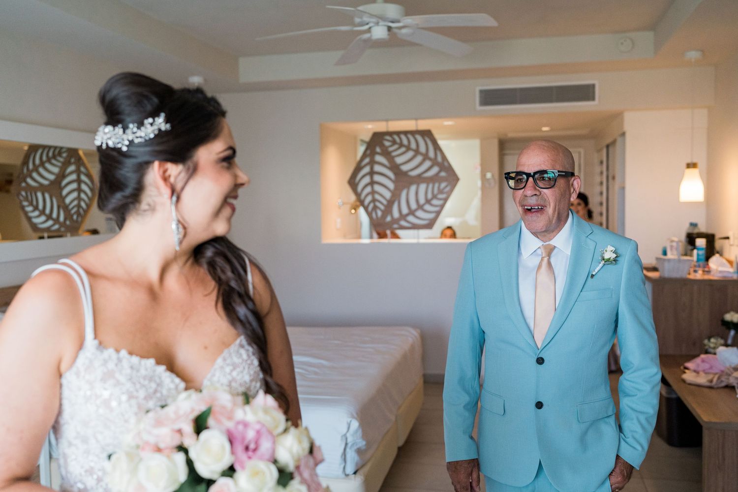 Emotional father reacting with joy seeing his daughter in her wedding gown for the first time.