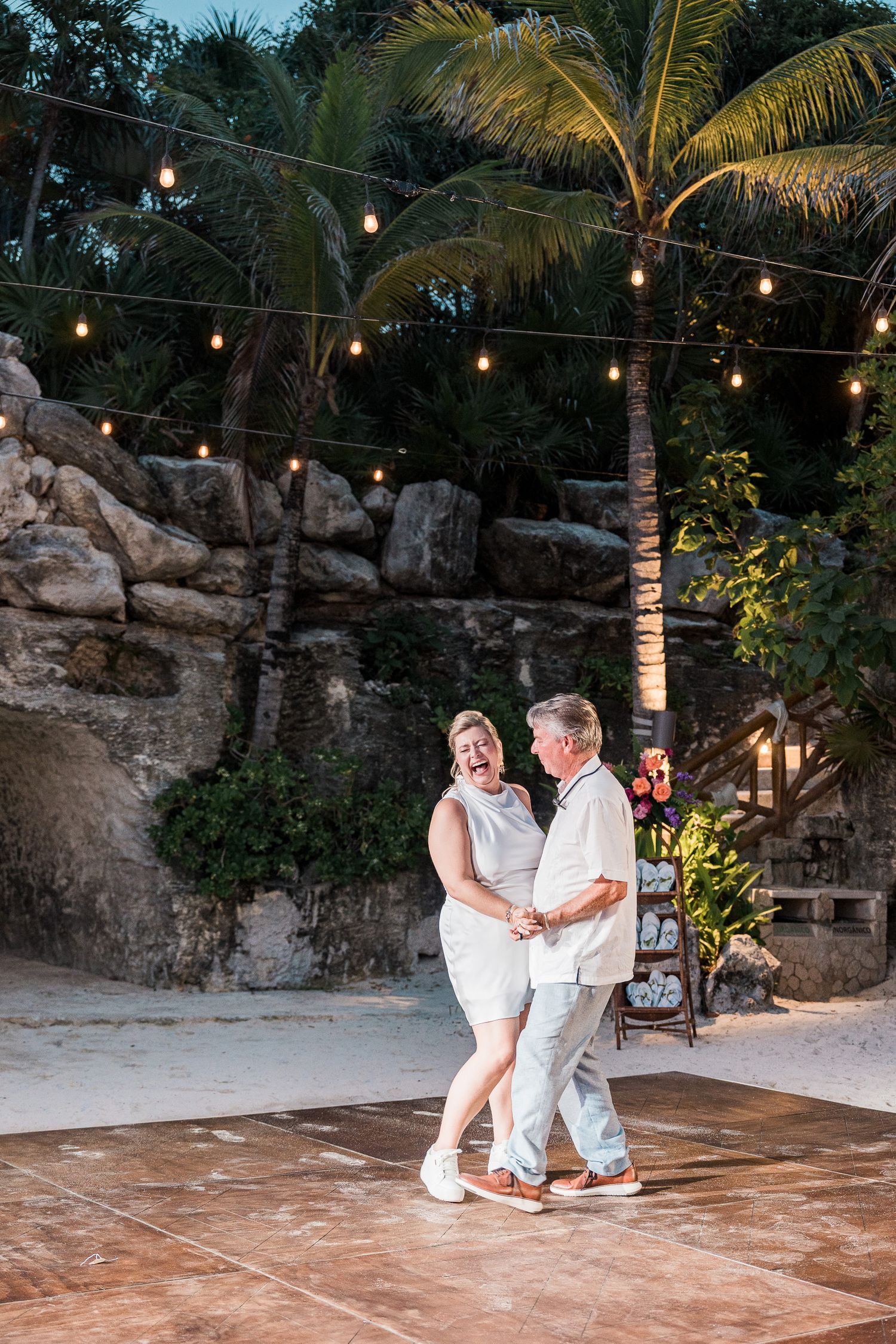 Hotel Xcaret México wedding Elderly couple dancing joyfully on outdoor dance floor at tropical beach wedding