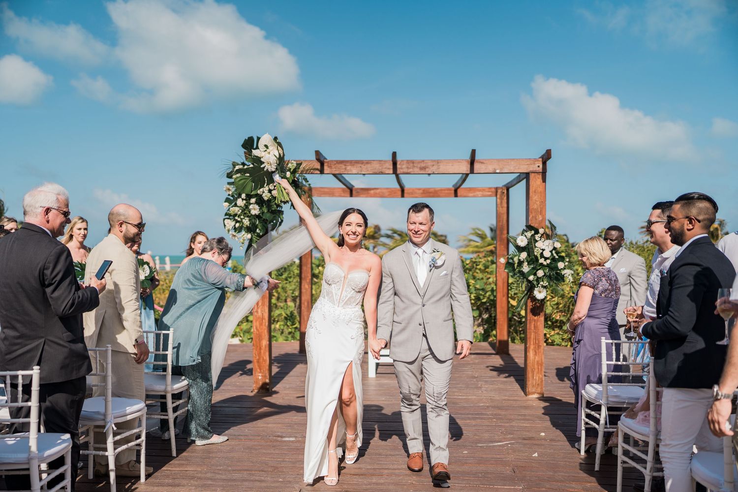 Bride and groom walk down the aisle after ceremony on a sunny outdoor at grand palladium costa mujeres wedding