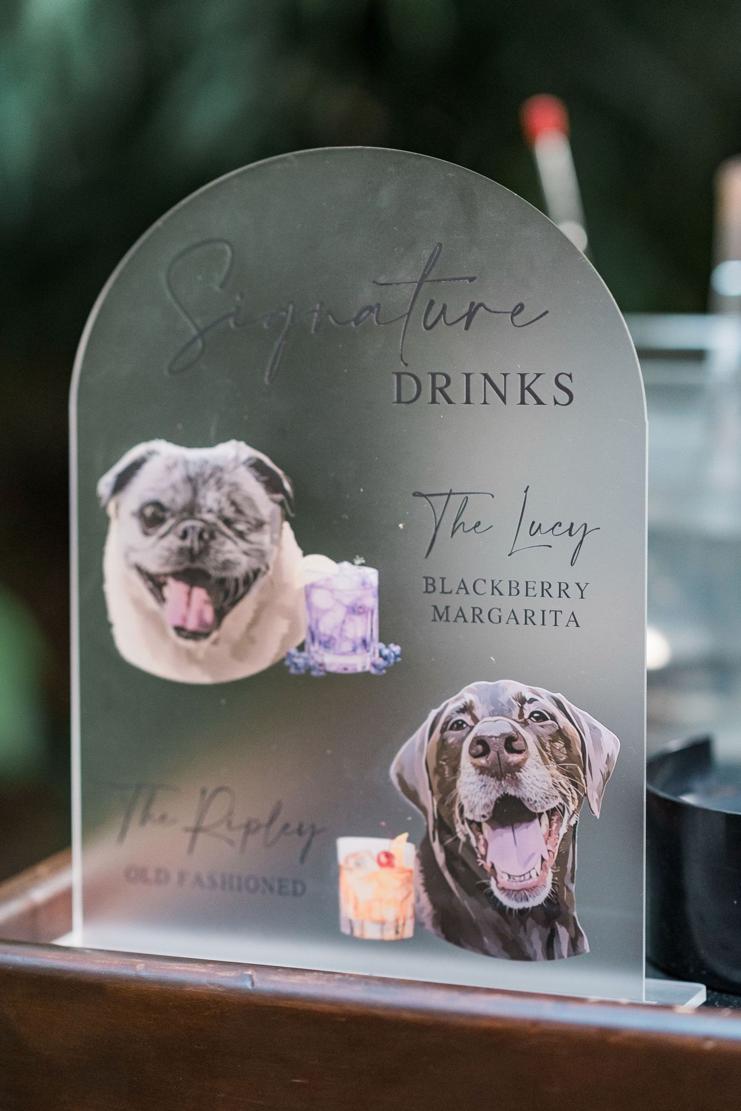 Secrets Akumal WeddinElegant acrylic wedding signature drinks sign featuring custom pet portraits of a pug and Labrador with cocktail menus.