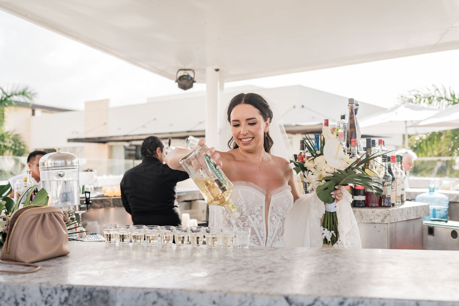 Bride in a lace wedding dress smiling at a marble bar grand palladium costa mujeres wedding