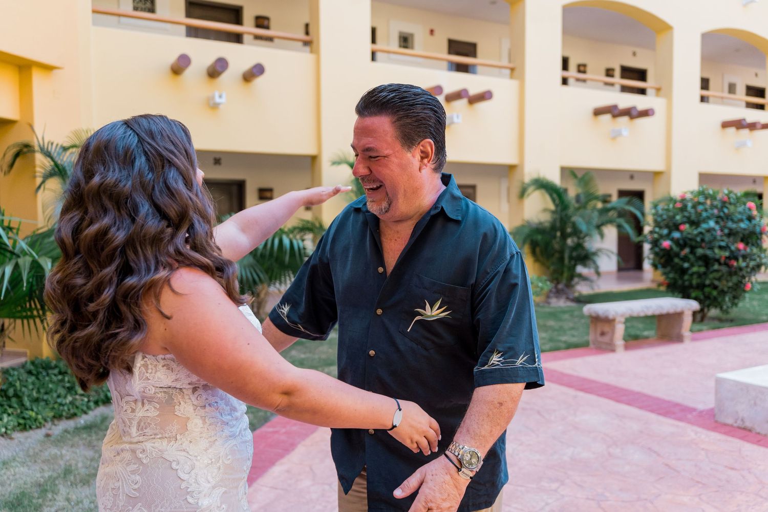 Emotional father-daughter first look moment at a tropical resort on the wedding day.
