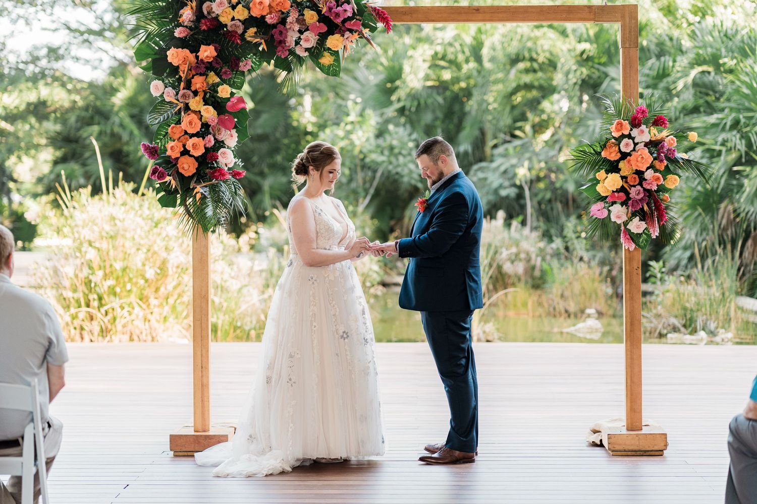 Secrets Akumal Wedding - Bride and groom exchange vows under a wooden arch adorned