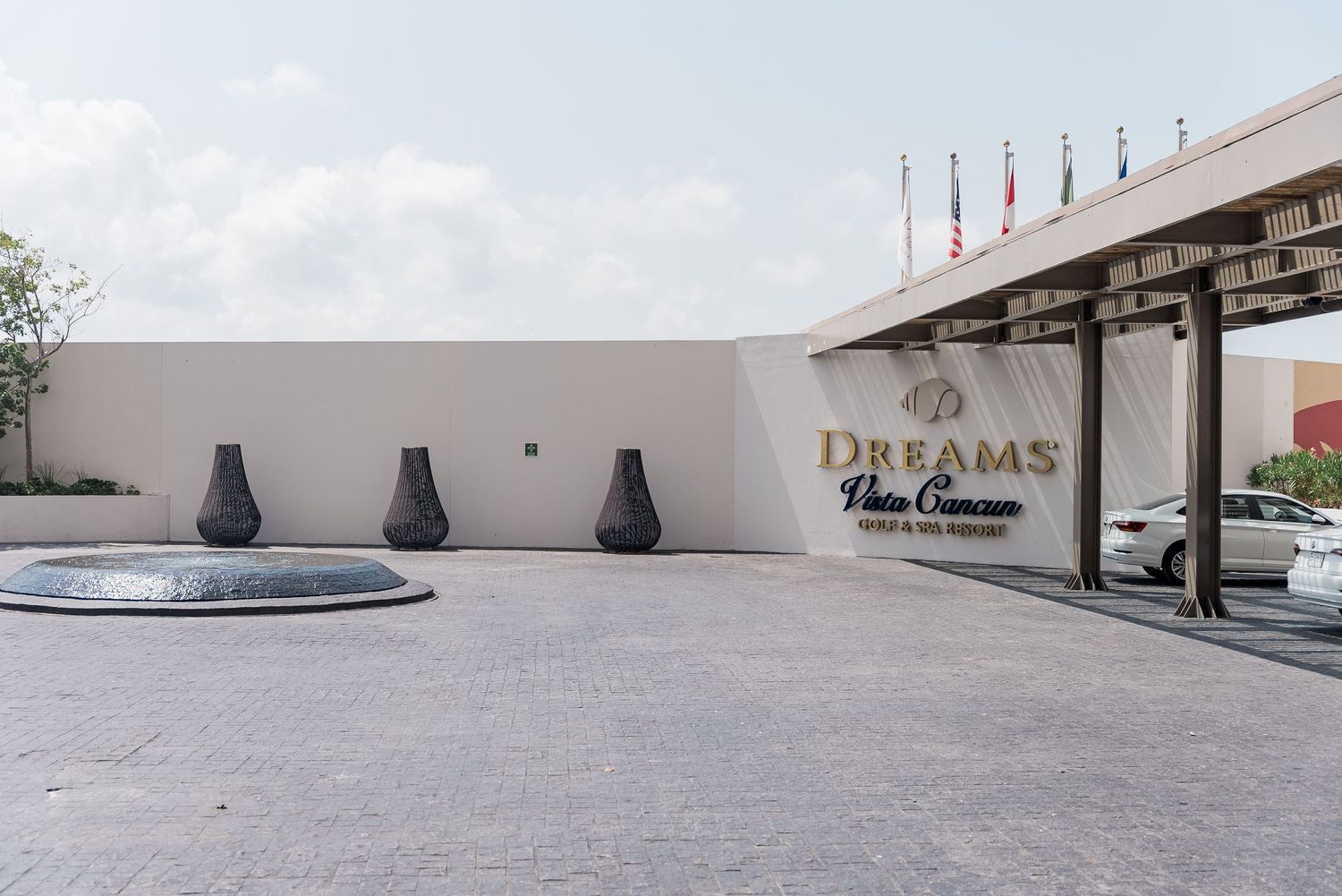Dreams Playa Cancun Resort and Spa entrance with modern architecture and fountain.