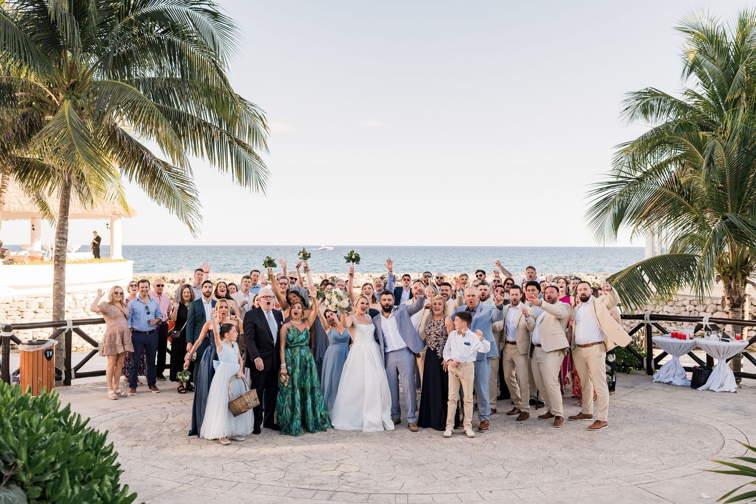Large wedding group photo on a tropical beach with palm trees, Hard Rock Riviera Maya wedding photographer