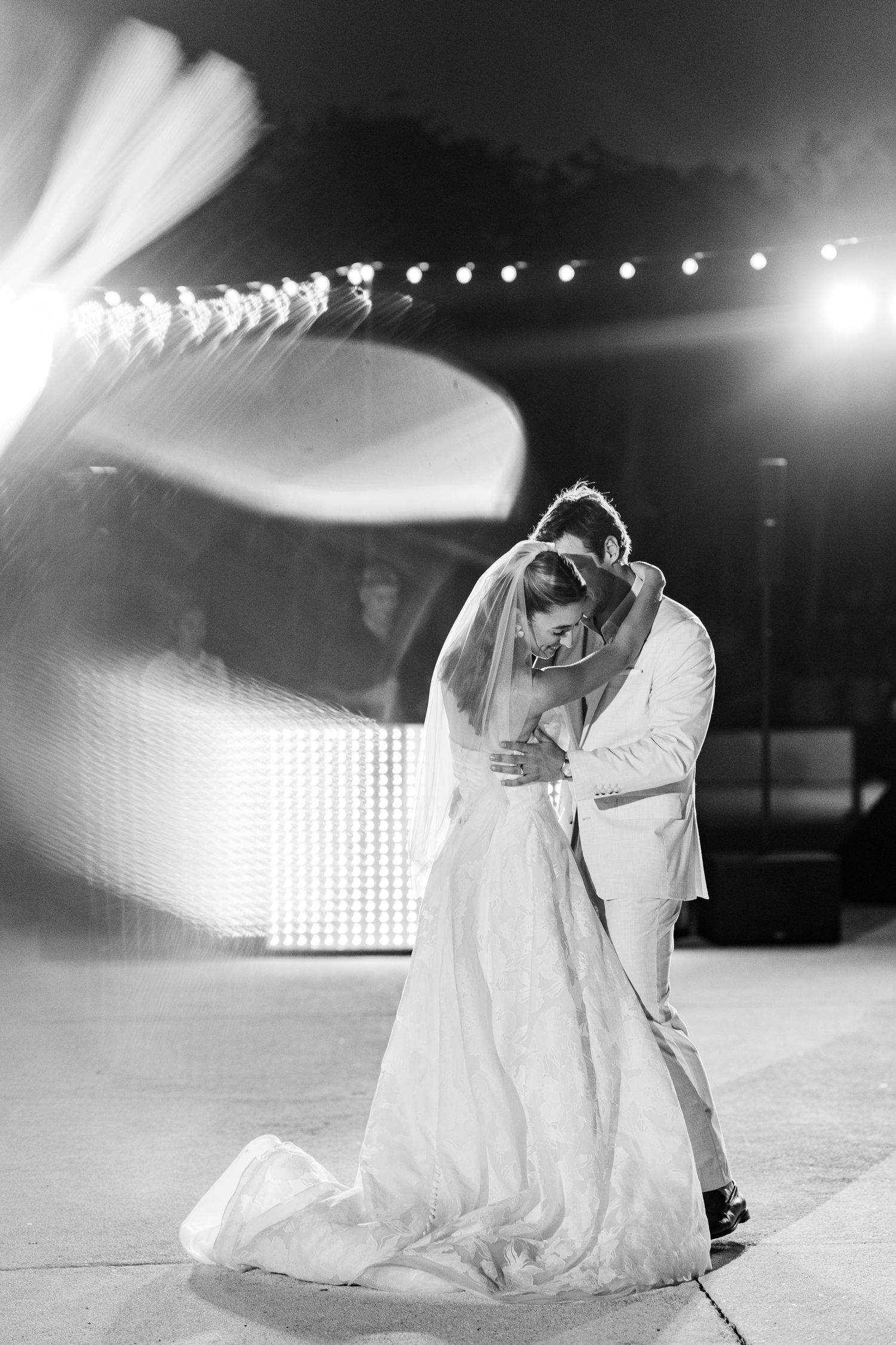 Black and white photo of bride and groom sharing first dance at wedding.