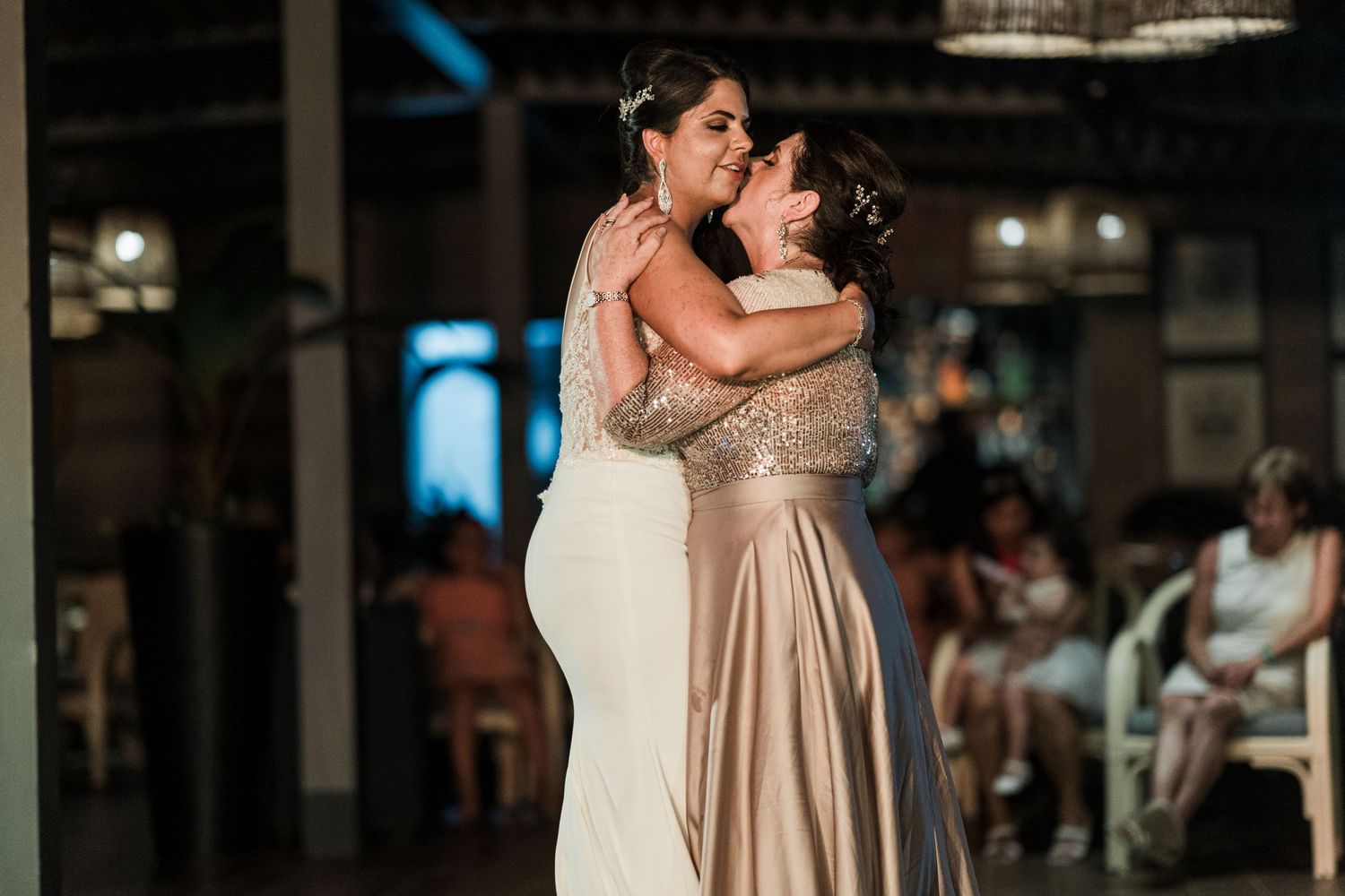 Bride and mother sharing an emotional embrace during a special dance at the wedding reception.