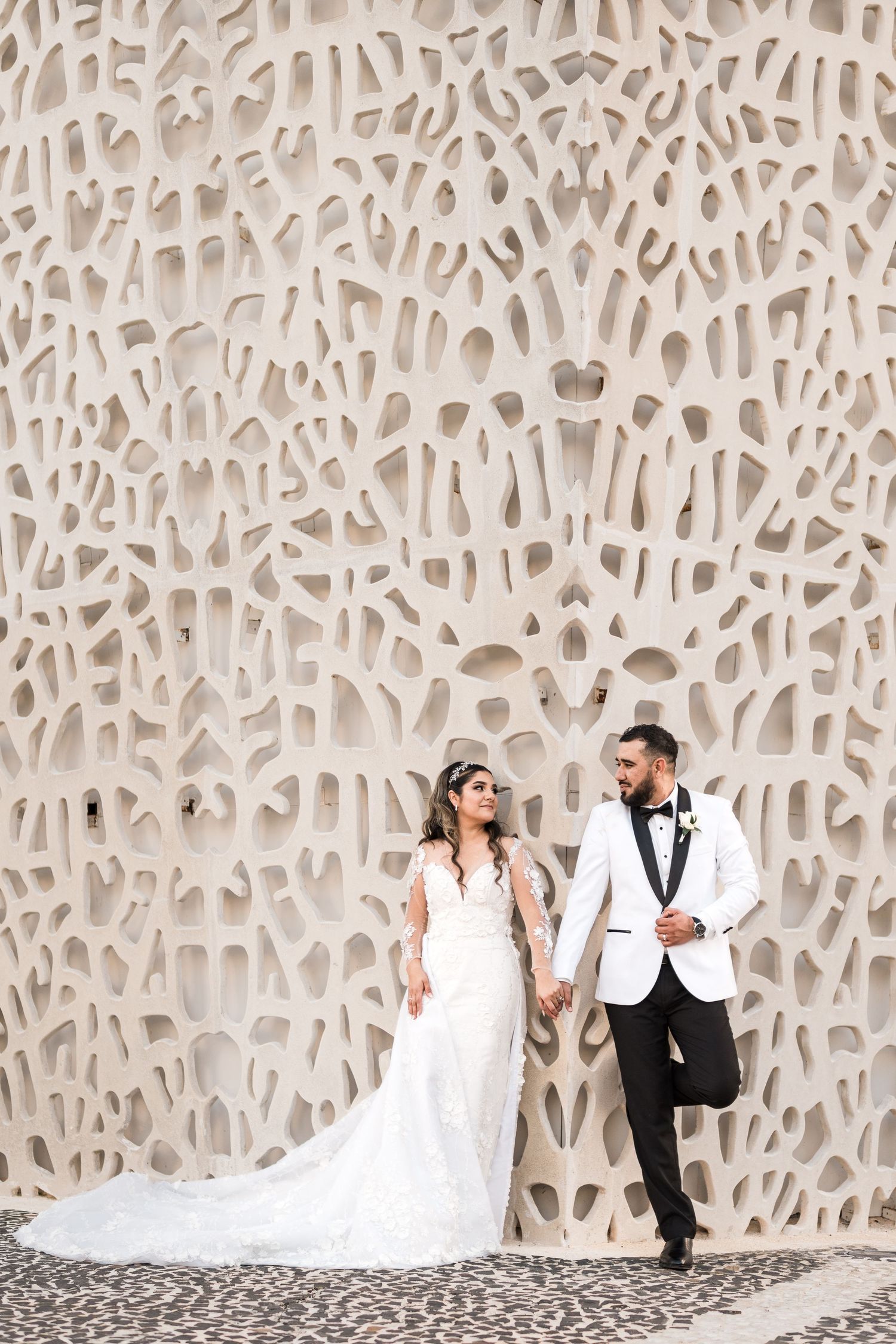 cabo wedding photography | couple posing on a wall with amazing architecture