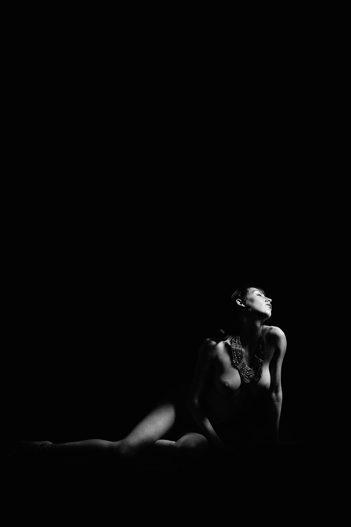 Dramatic black and white portrait of a dancer in low-key lighting creating artistic silhouette.