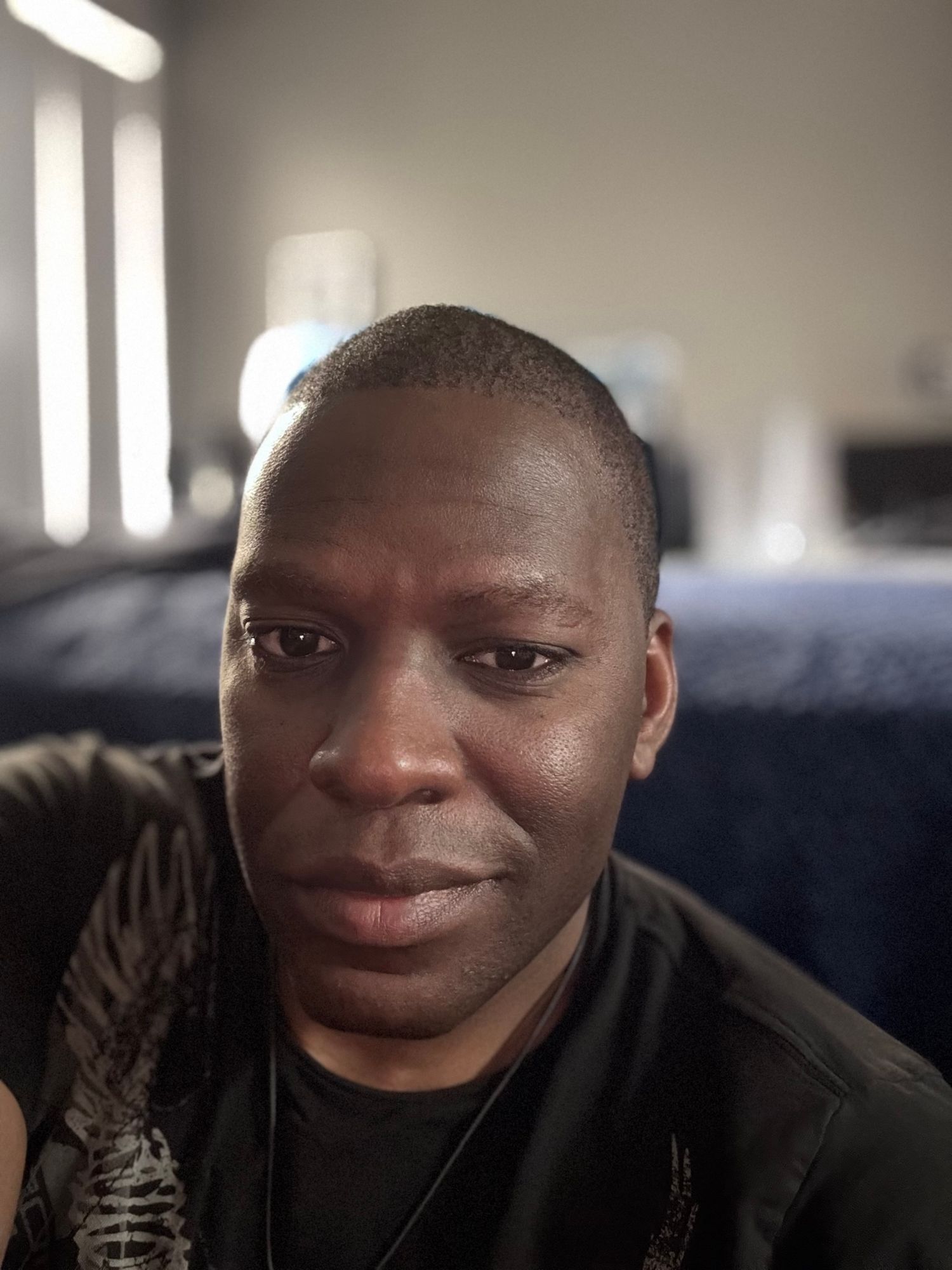 Indoor close-up portrait in natural lighting with a dark background.