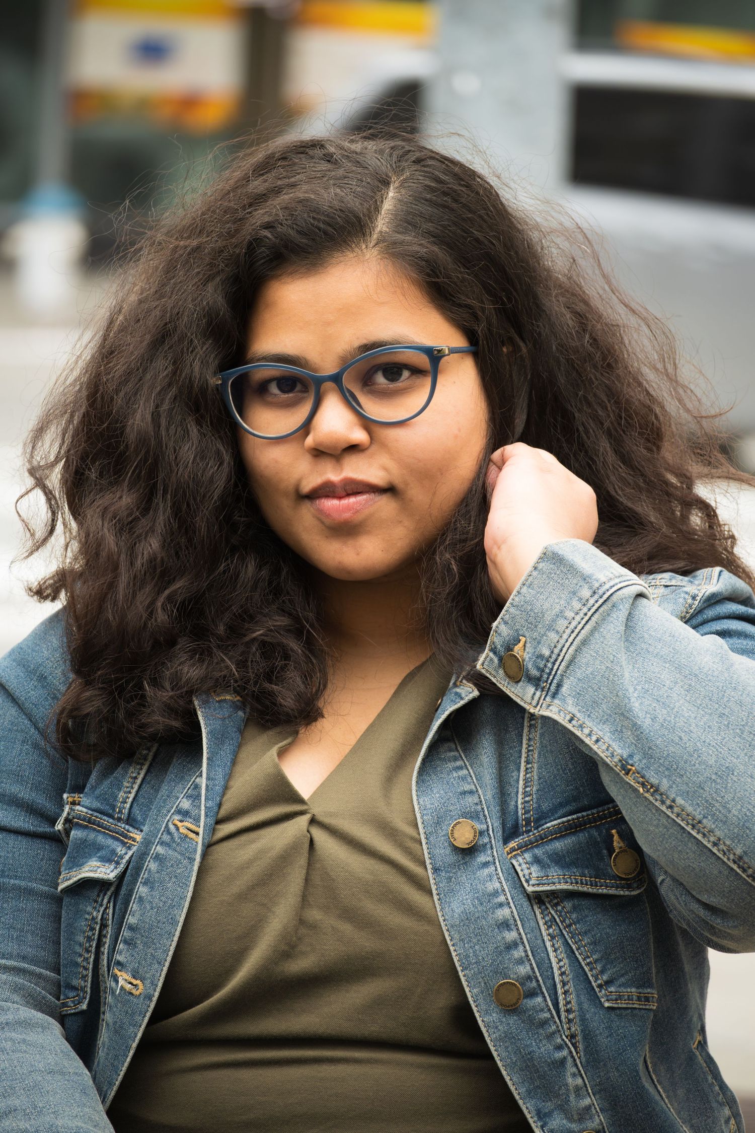 A series of fashion portraits showing someone in a denim jacket and olive top posing with different expressions.