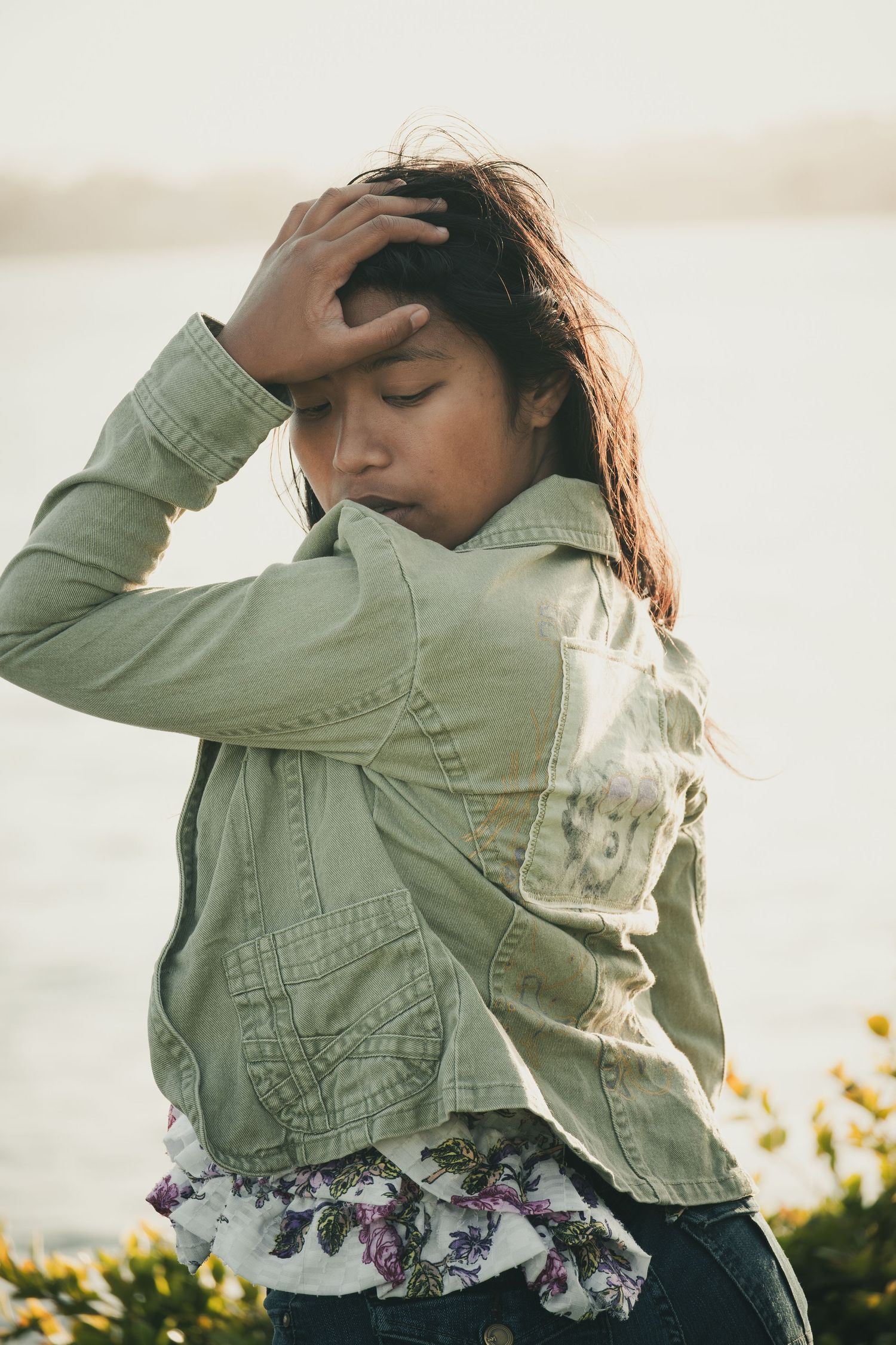 A person in a mint green denim jacket poses against a bright background in a series of artistic fashion shots.