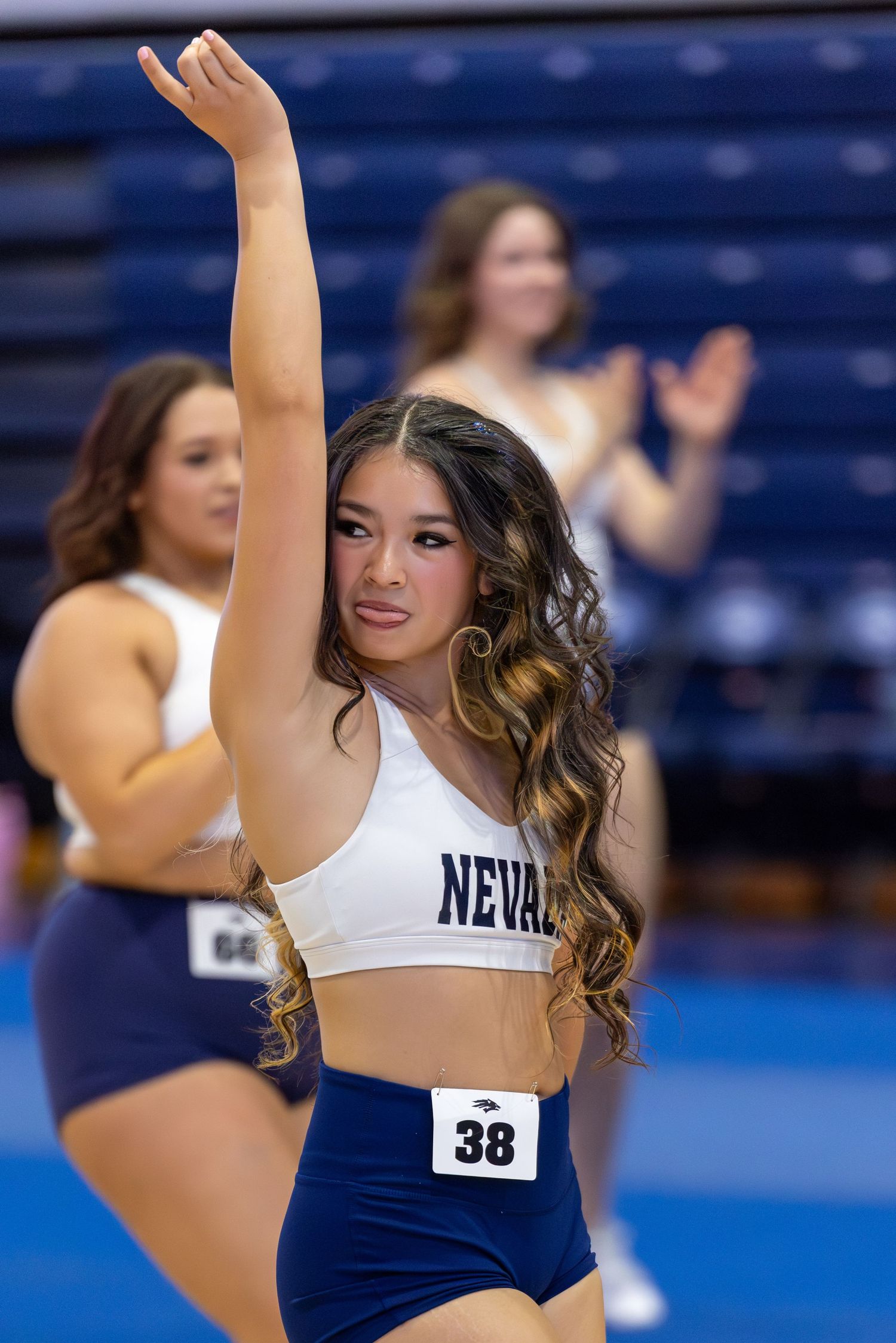 University of Nevada cheerleader #38 performs with arm raised at a college sports event.