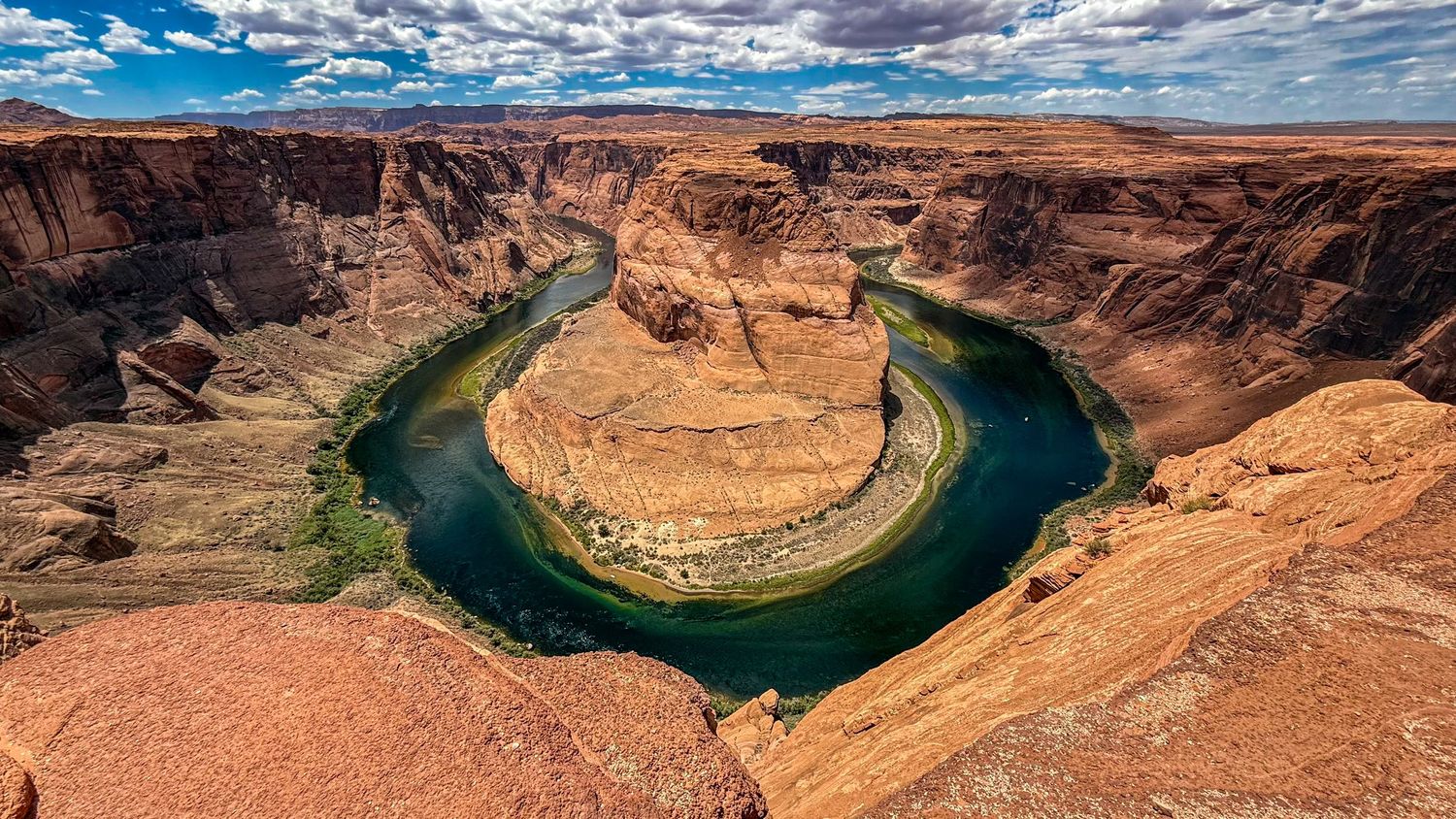 Horseshoe Bend on the Colorado River shows a dramatic meander carved through red sandstone cliffs.