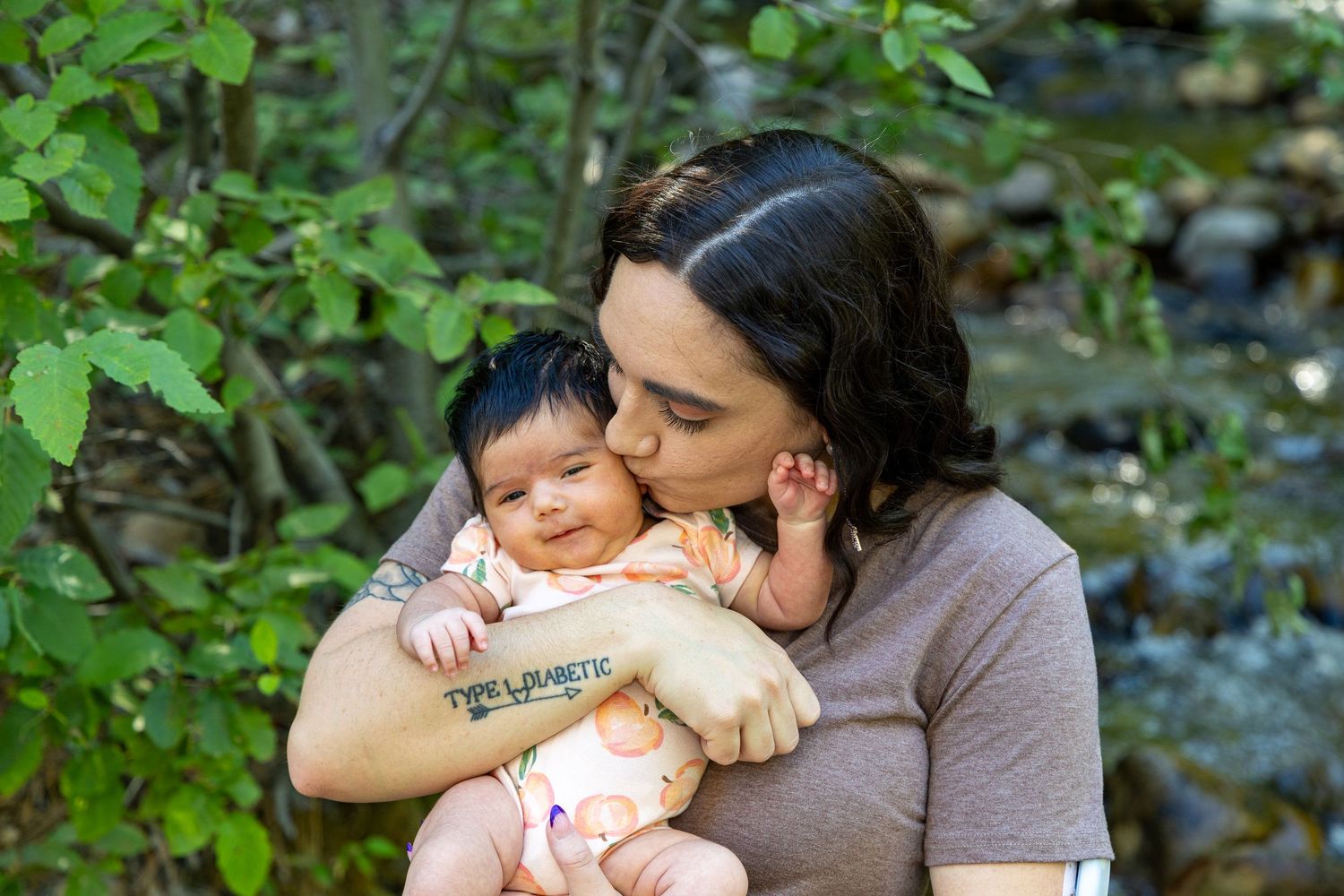 Parent and child share a tender moment together in a lush green outdoor setting.