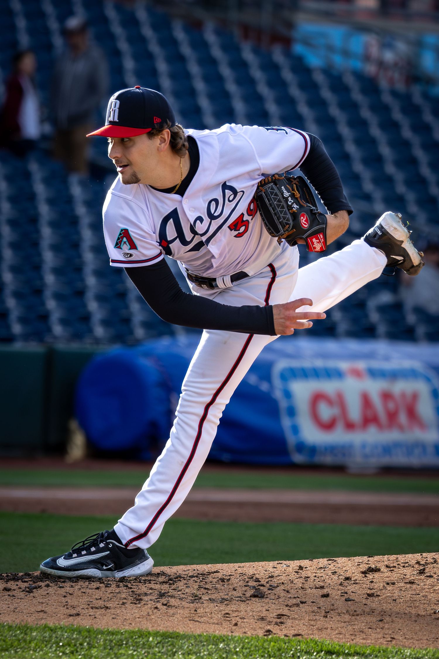 Reno Aces pitcher in white uniform delivers a pitch from the mound during a minor league baseball game.