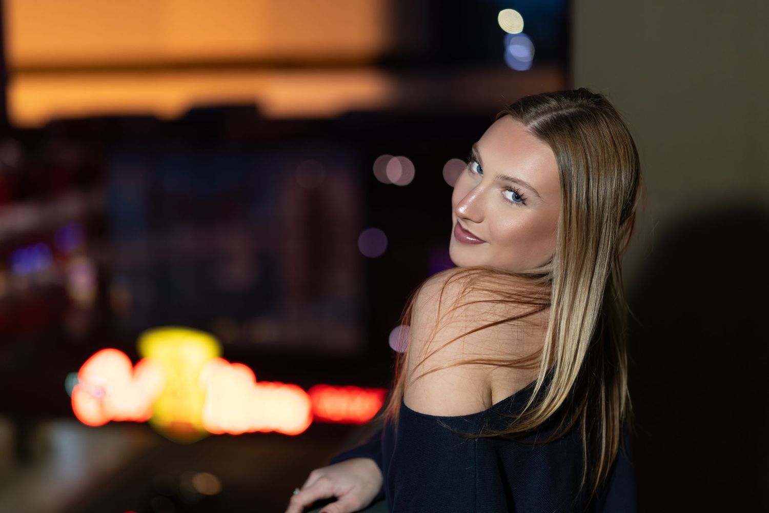 A collection of nighttime portraits showing different angles of someone posing in moody lighting with bokeh effects.