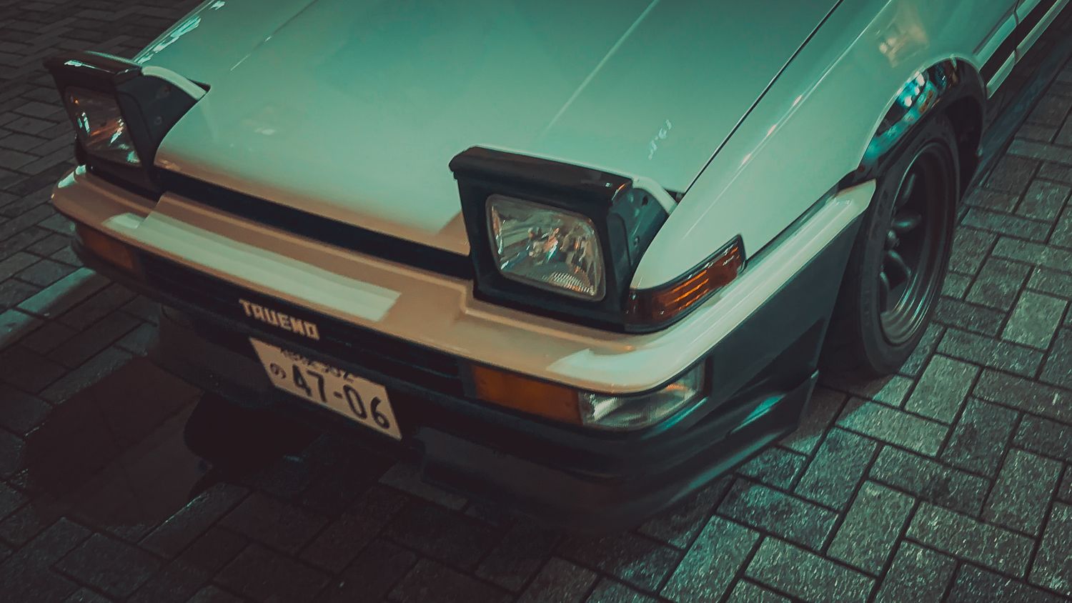 Classic mint green sports car photographed from a low angle showing sleek bodywork.