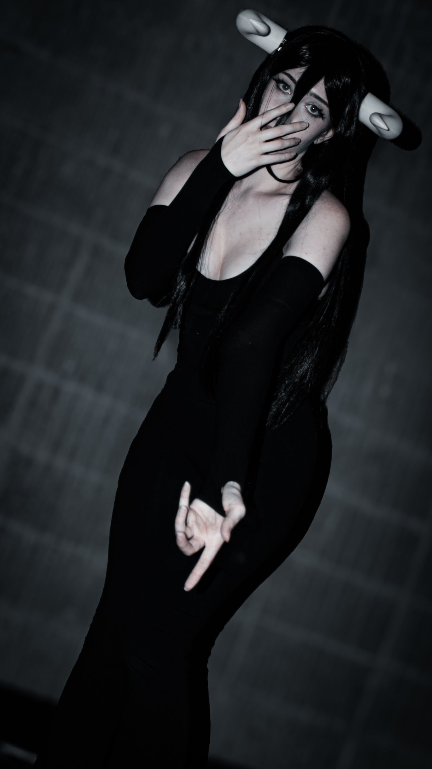 Dramatic black and white photos of someone posing in dark clothing.
