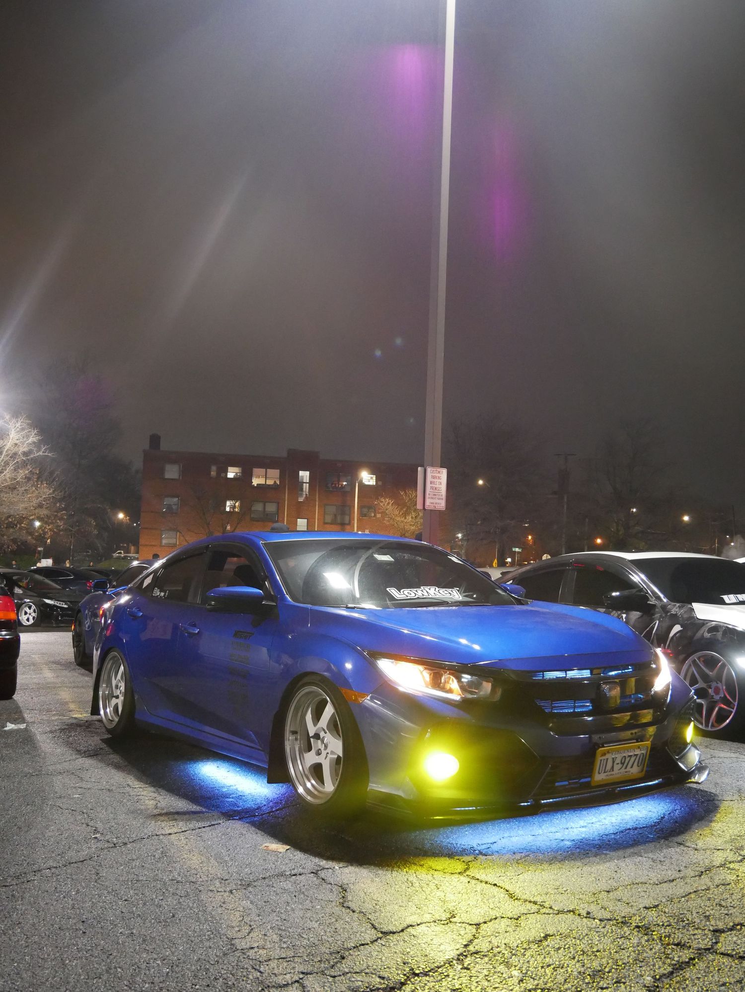 Modified blue sports car with custom lighting displayed at night.