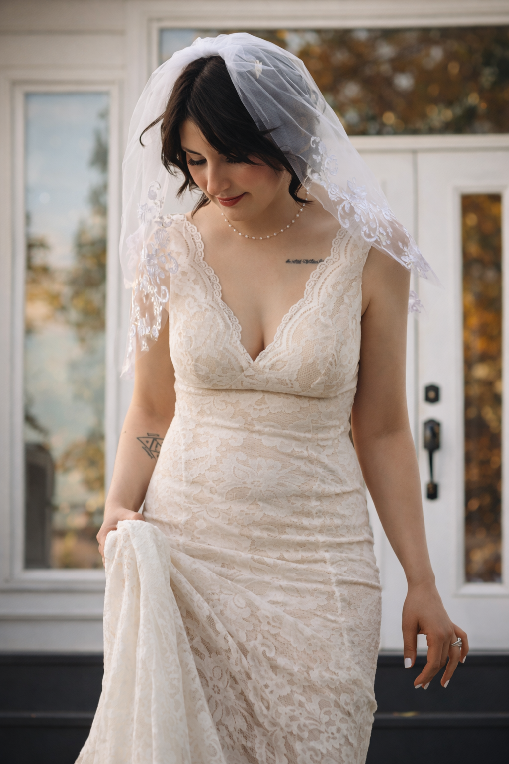 Close-up details of an elegant white lace wedding dress with v-neckline and delicate embroidery patterns.
