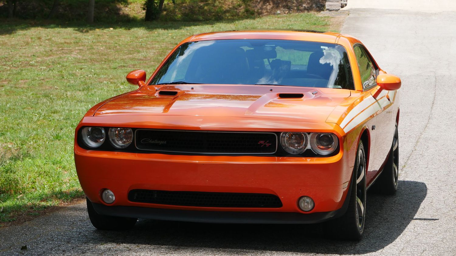 Front three-quarter view of an orange Dodge Challenger with retro-inspired design elements.