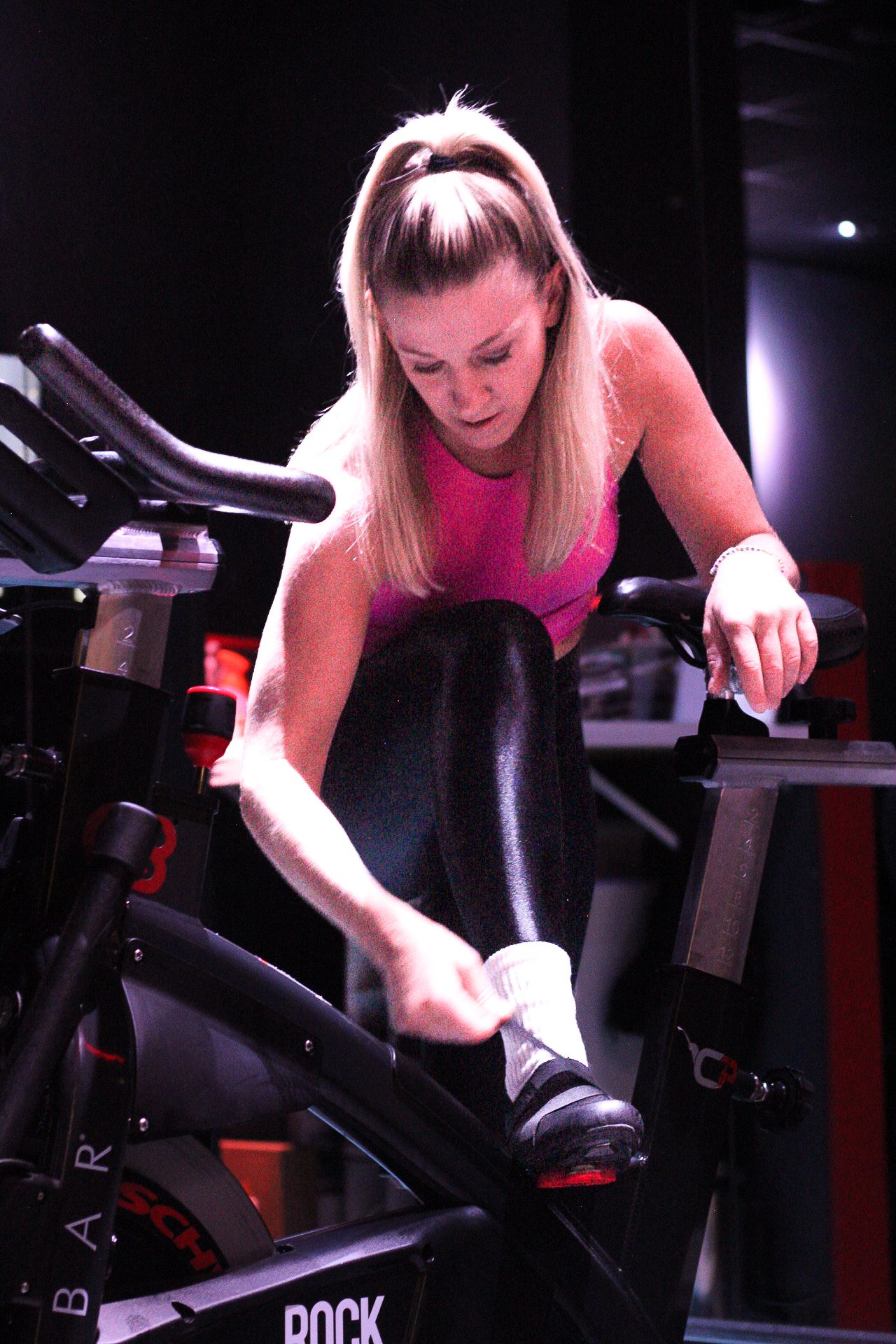 Katie Brantley tightens cycling shoe before class