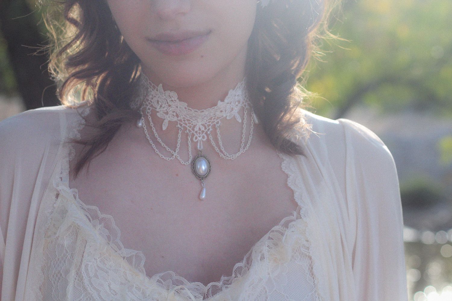 Delicate white lace choker necklace with pearl pendant worn with Victorian-style lacey blouse in soft natural light.