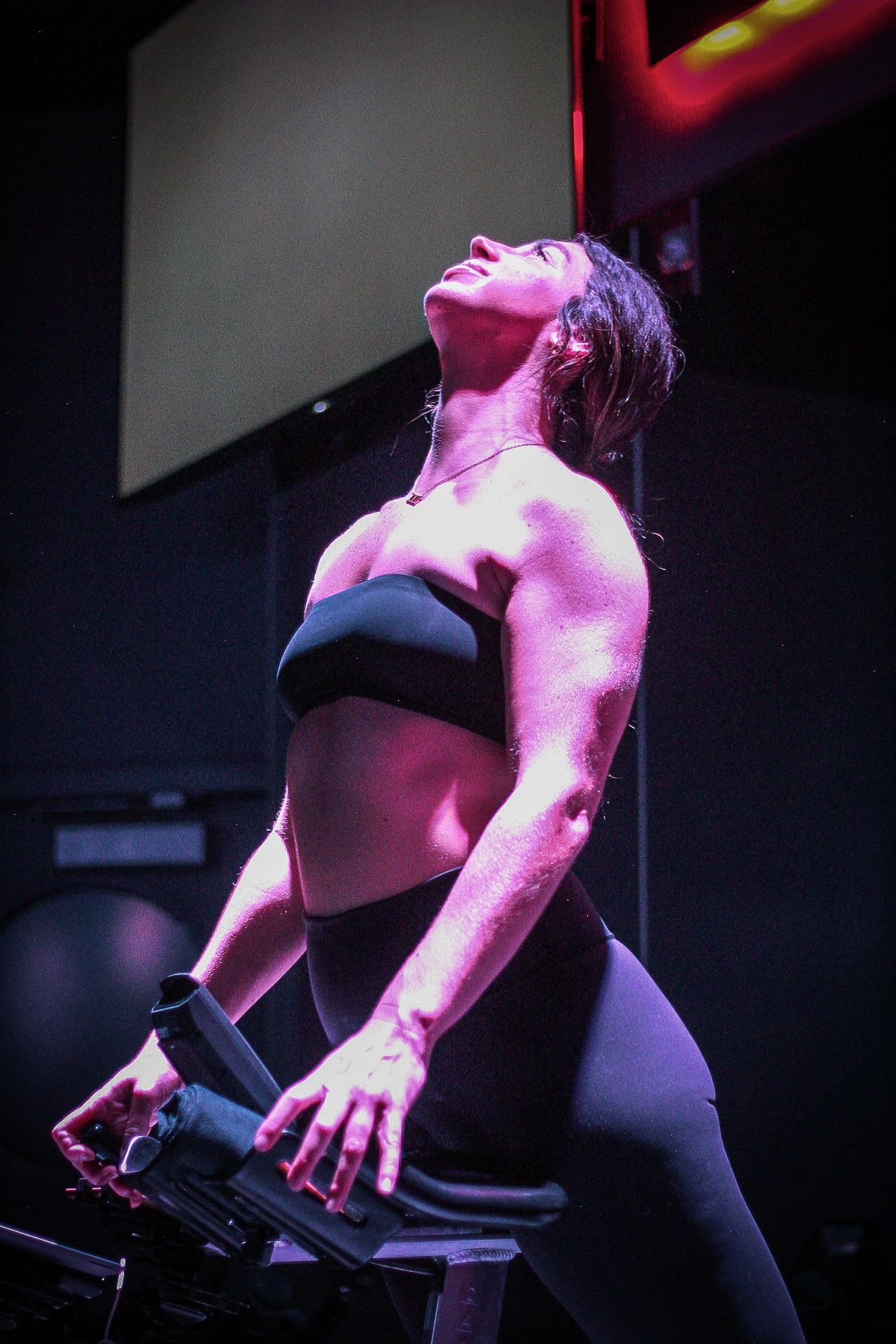 Rose Schleifman stretches on instructor bike at Cyclebar LoHi