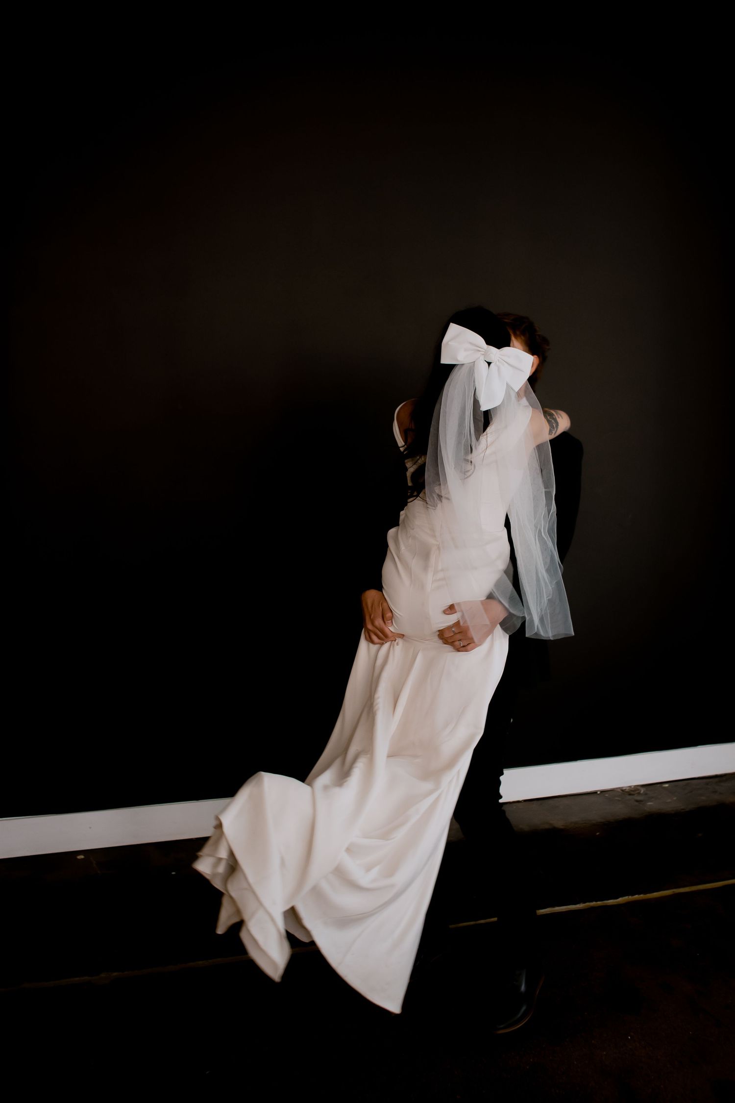 A ghostly figure in white fabric creates an eerie movement sequence against a dark background.