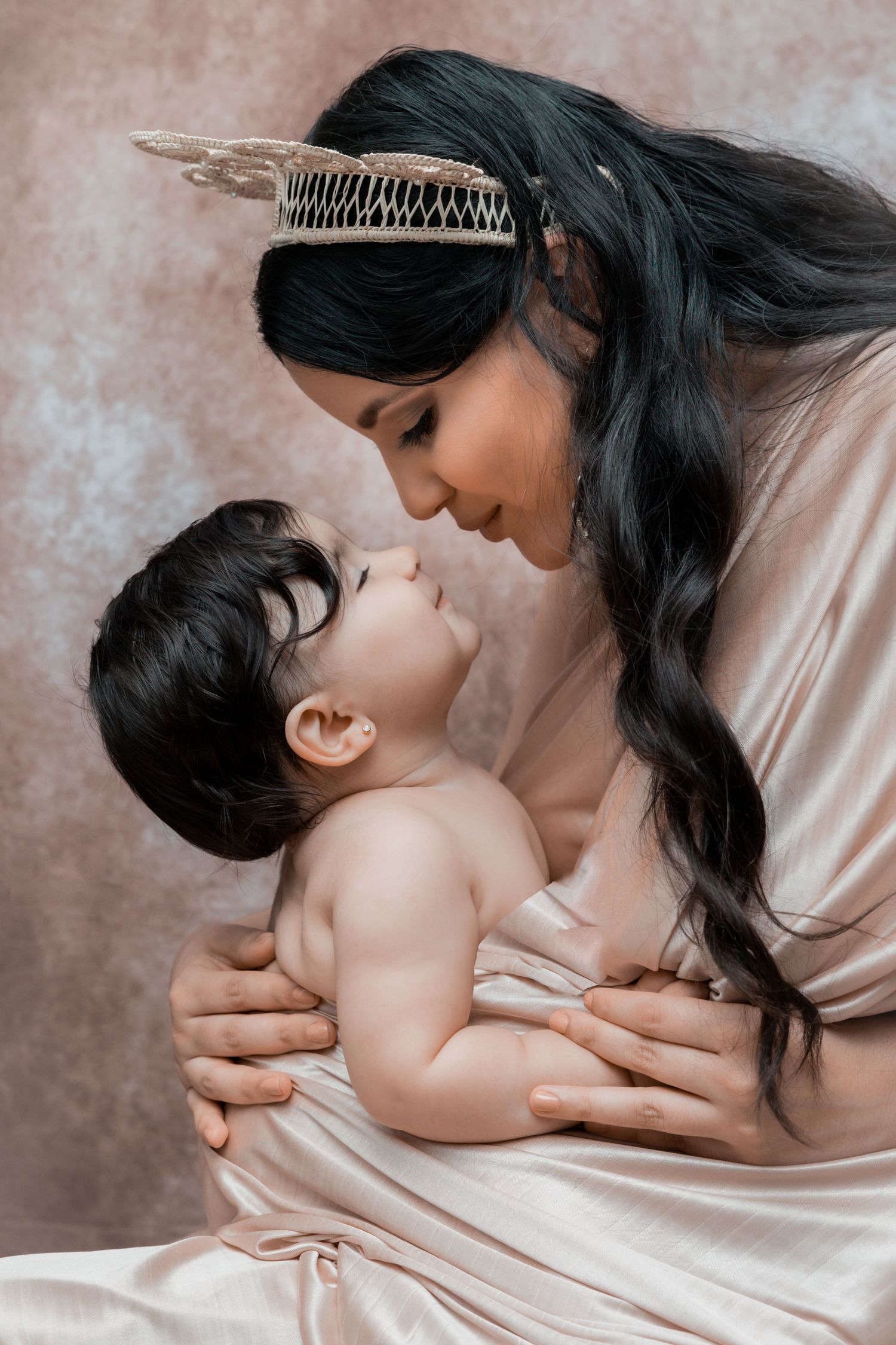 Intimate birthday portrait of a mother smiling at her baby during a soft indoor photography session