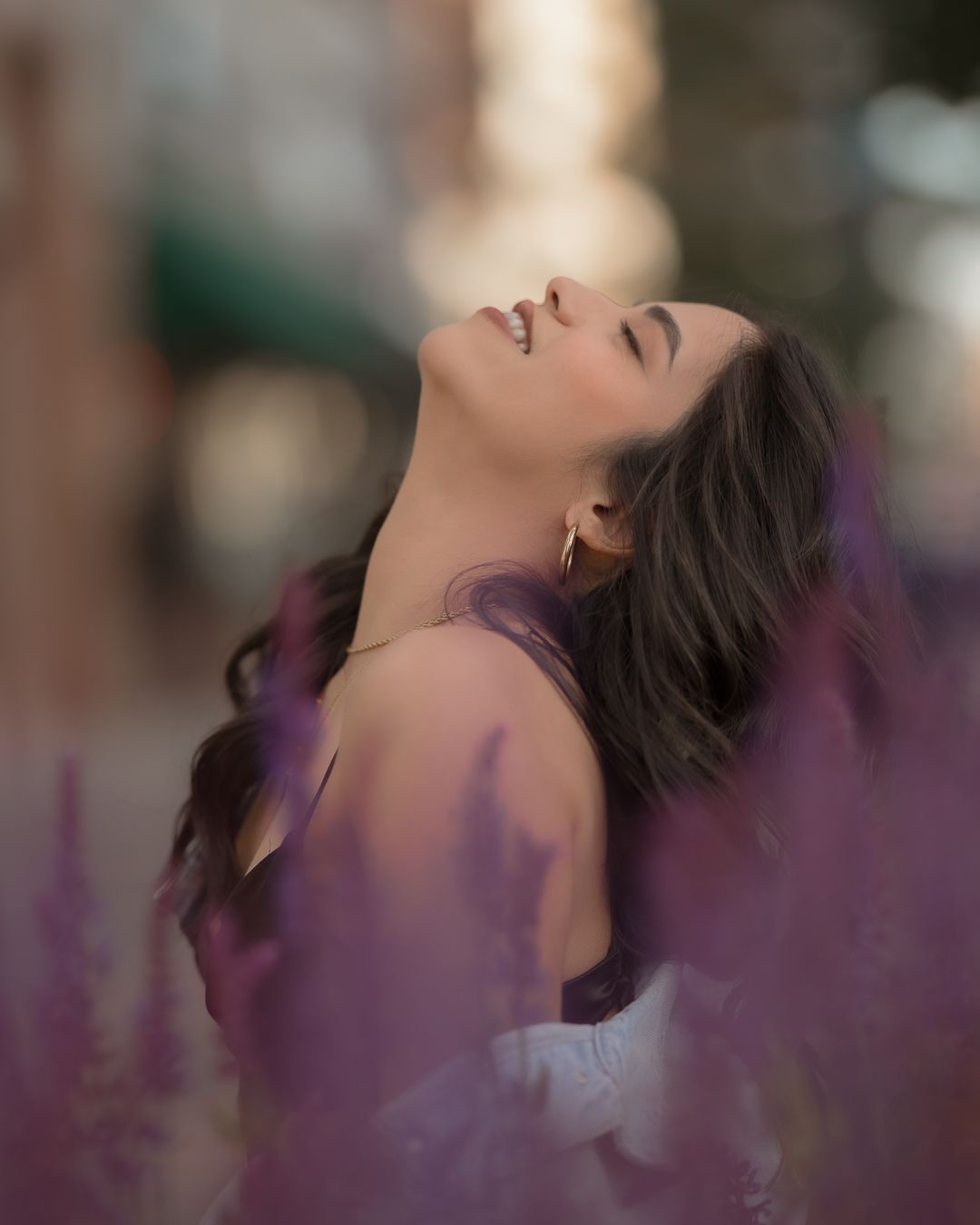 Candid close-up portrait of a woman smiling with her eyes closed during a relaxed birthday photoshoot