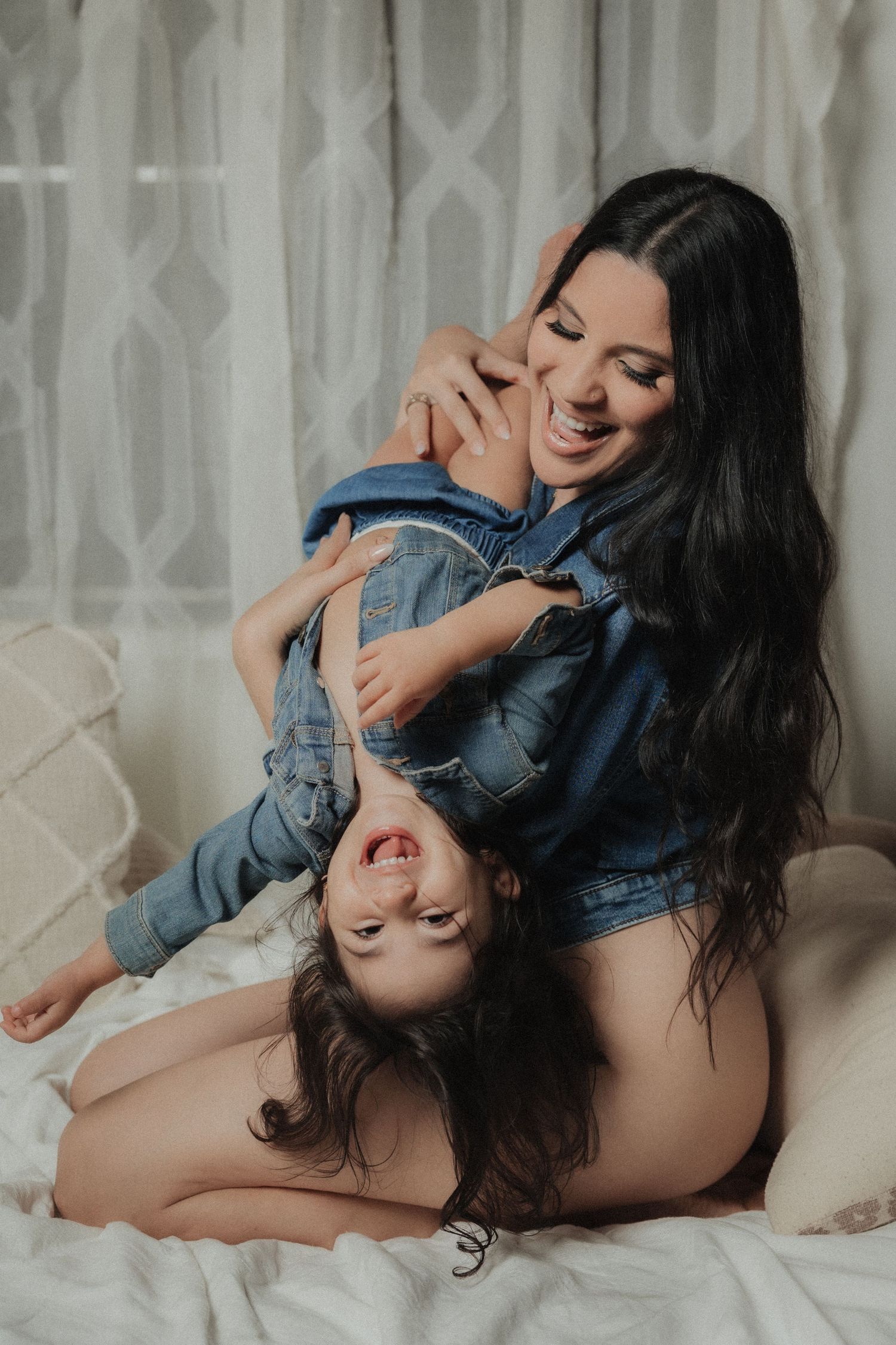 Intimate portrait of a mother playing with her baby during a soft indoor family photography session
