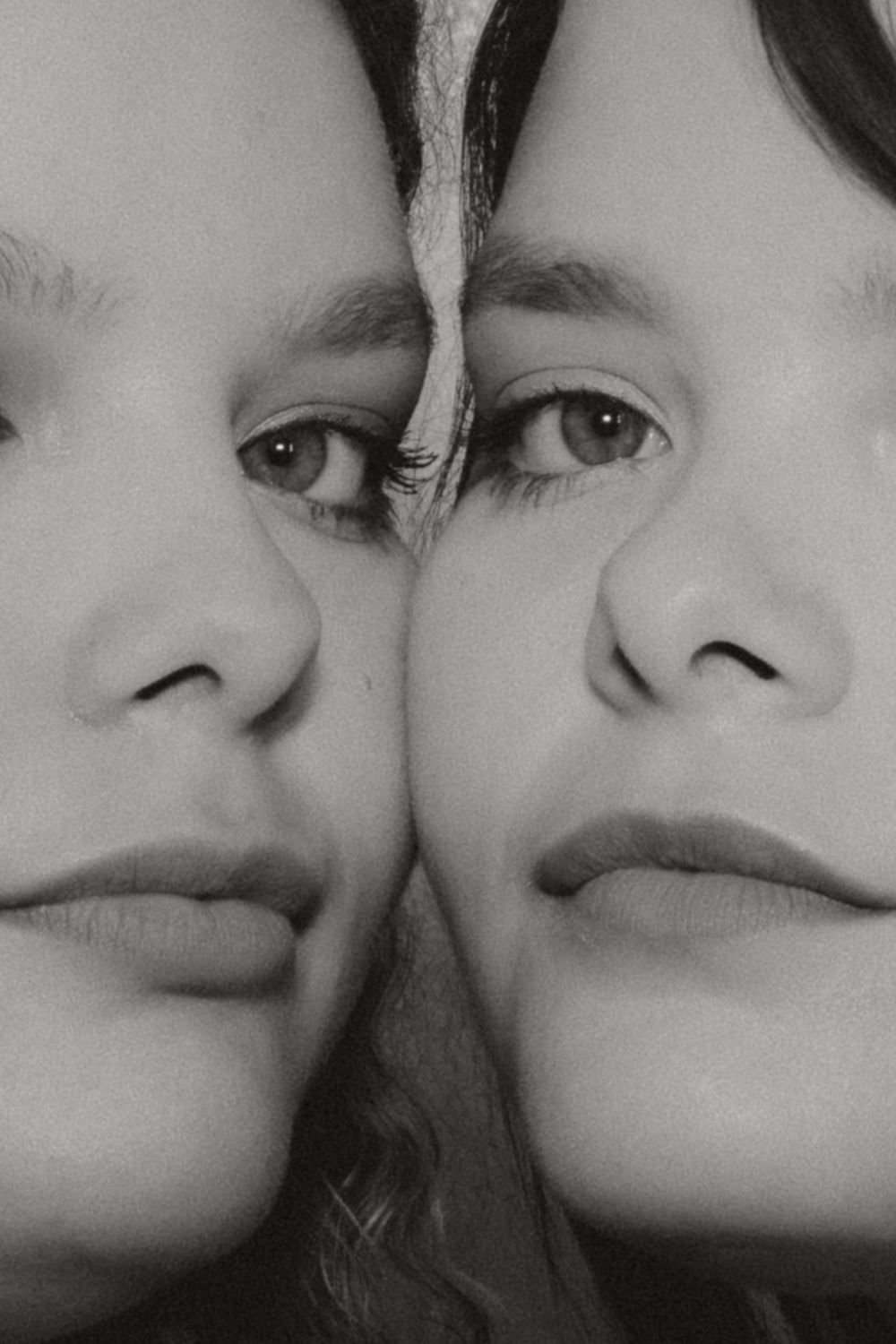 Artistic black and white close-up portrait focusing on the eyes and faces of two women