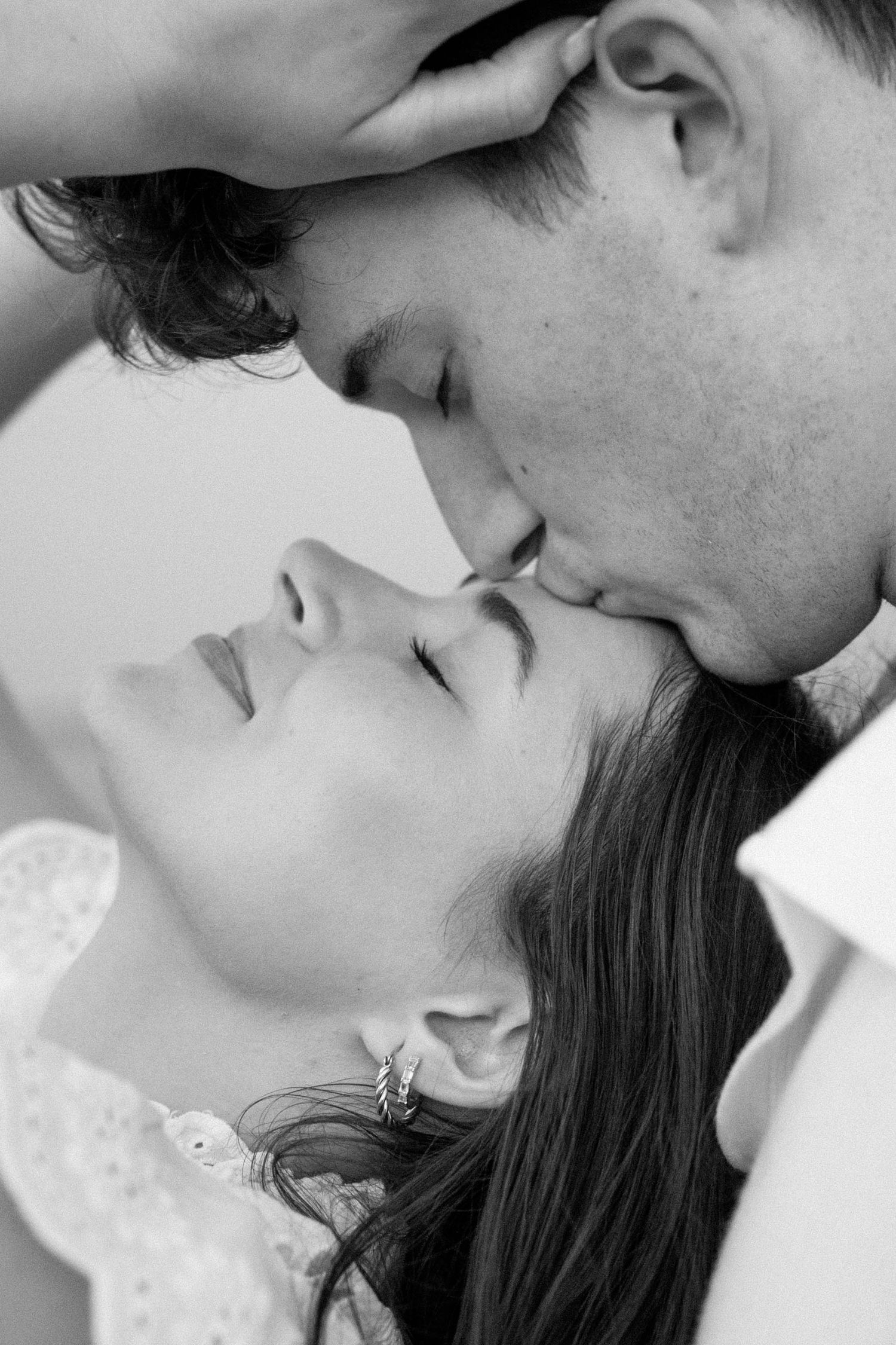 Close-up black and white portrait of a romantic couple in an intimate moment.
