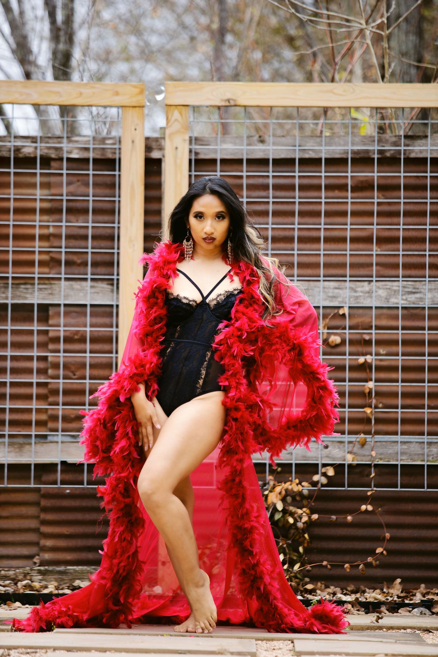 Boudoir standing outside in one-piece lingerie with red feathered robe