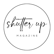 Shutter Up Magazine logo in elegant script font inside a minimalist black circle on white background.