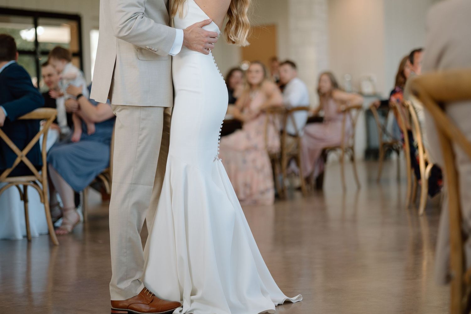 A close-up of a wedding couple dancing, showing their elegant attire.