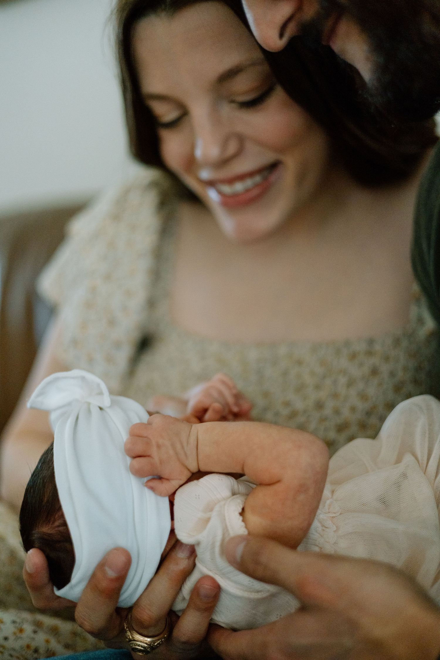 A tender moment showing tiny baby feet being cradled by caring hands in a warm, intimate setting.