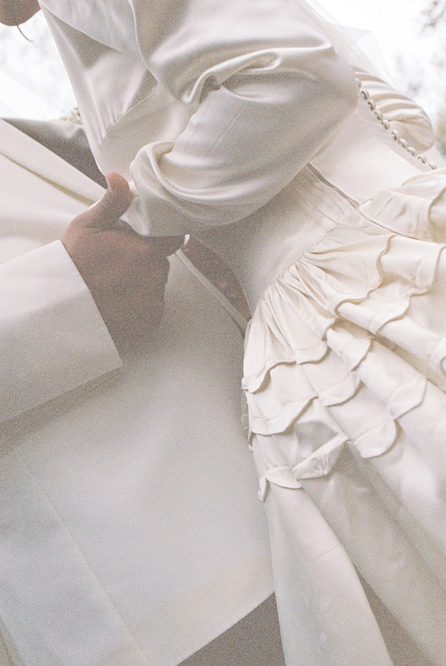 Close-up detail of white ruffles and fabric from a wedding dress.