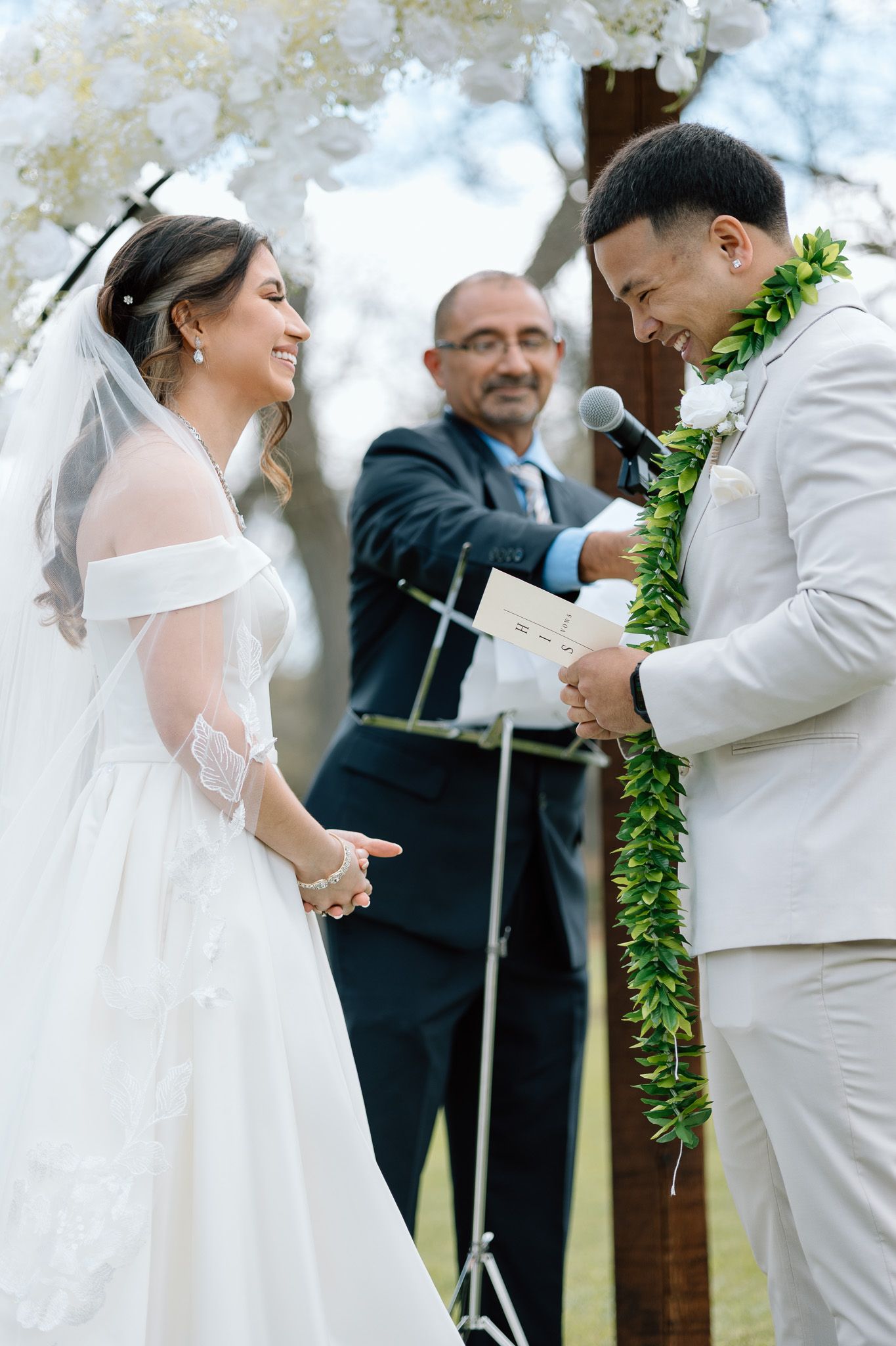 Wedding ceremony moment under cloudy skies with couple exchanging vows before an officiant.