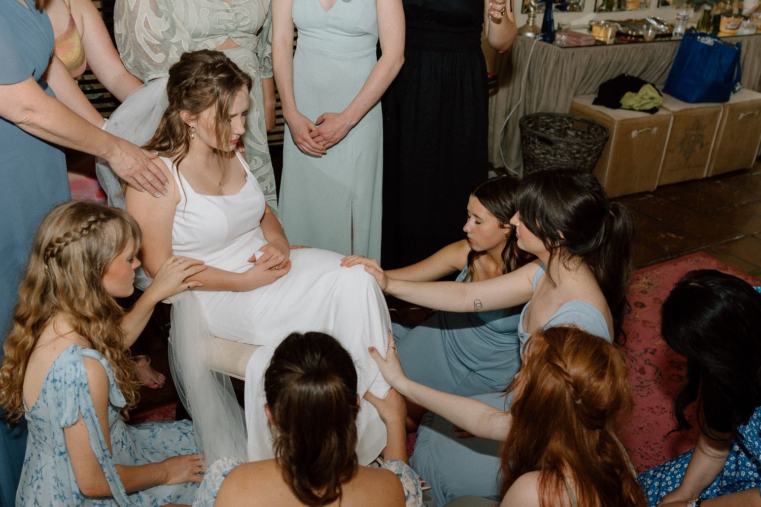 Wedding celebration scene showing group of attendees gathered in casual indoor setting.