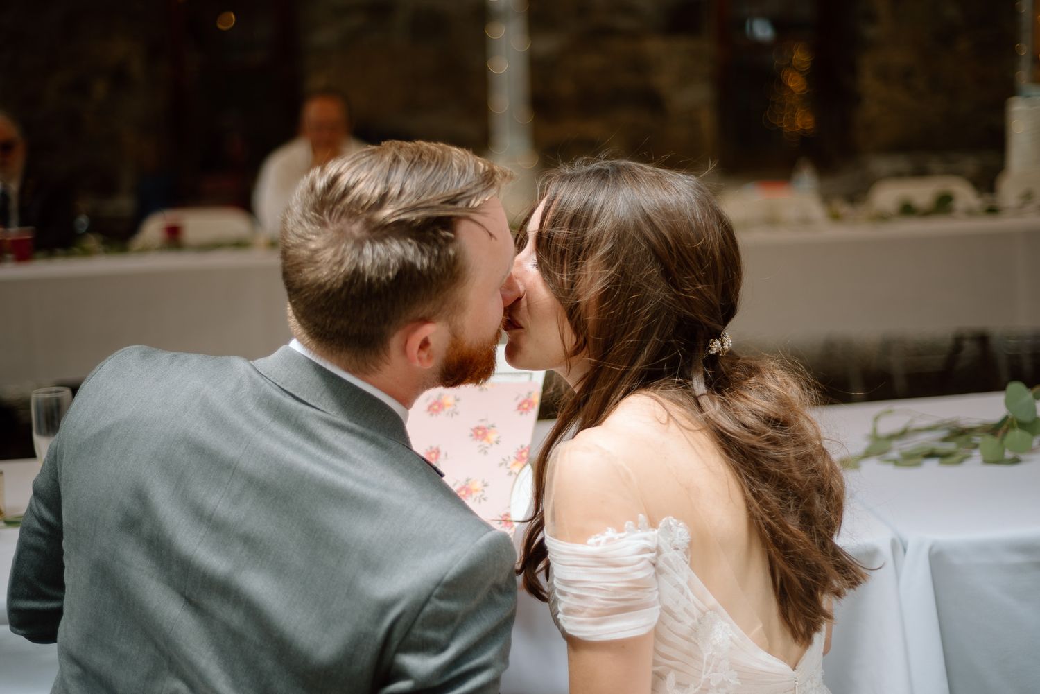 A tender moment shared between newlyweds at their reception table.