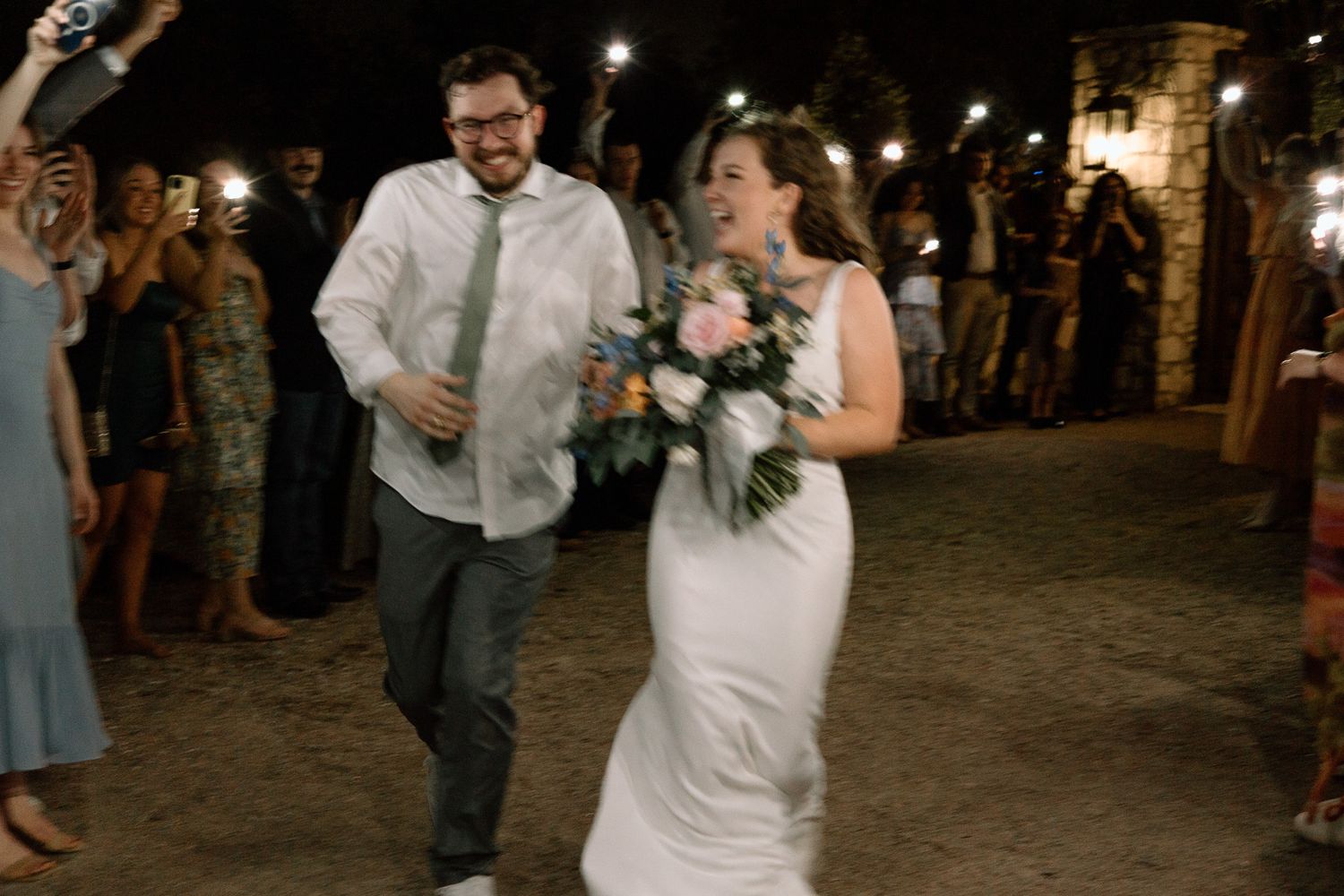 Wedding exit celebration with guests holding sparklers at night.