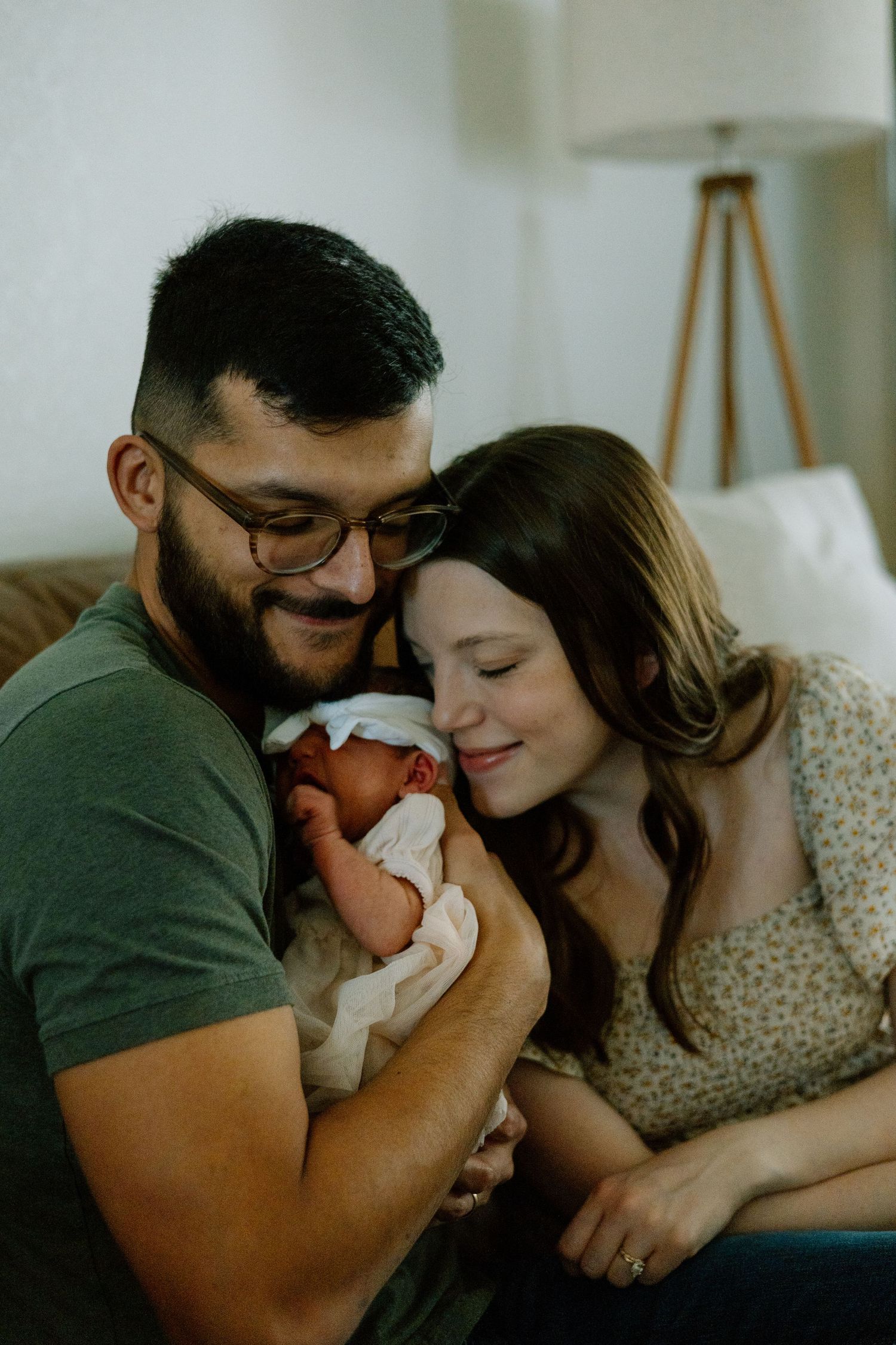 An intimate family moment captured in a living room with soft lighting and cozy furniture.